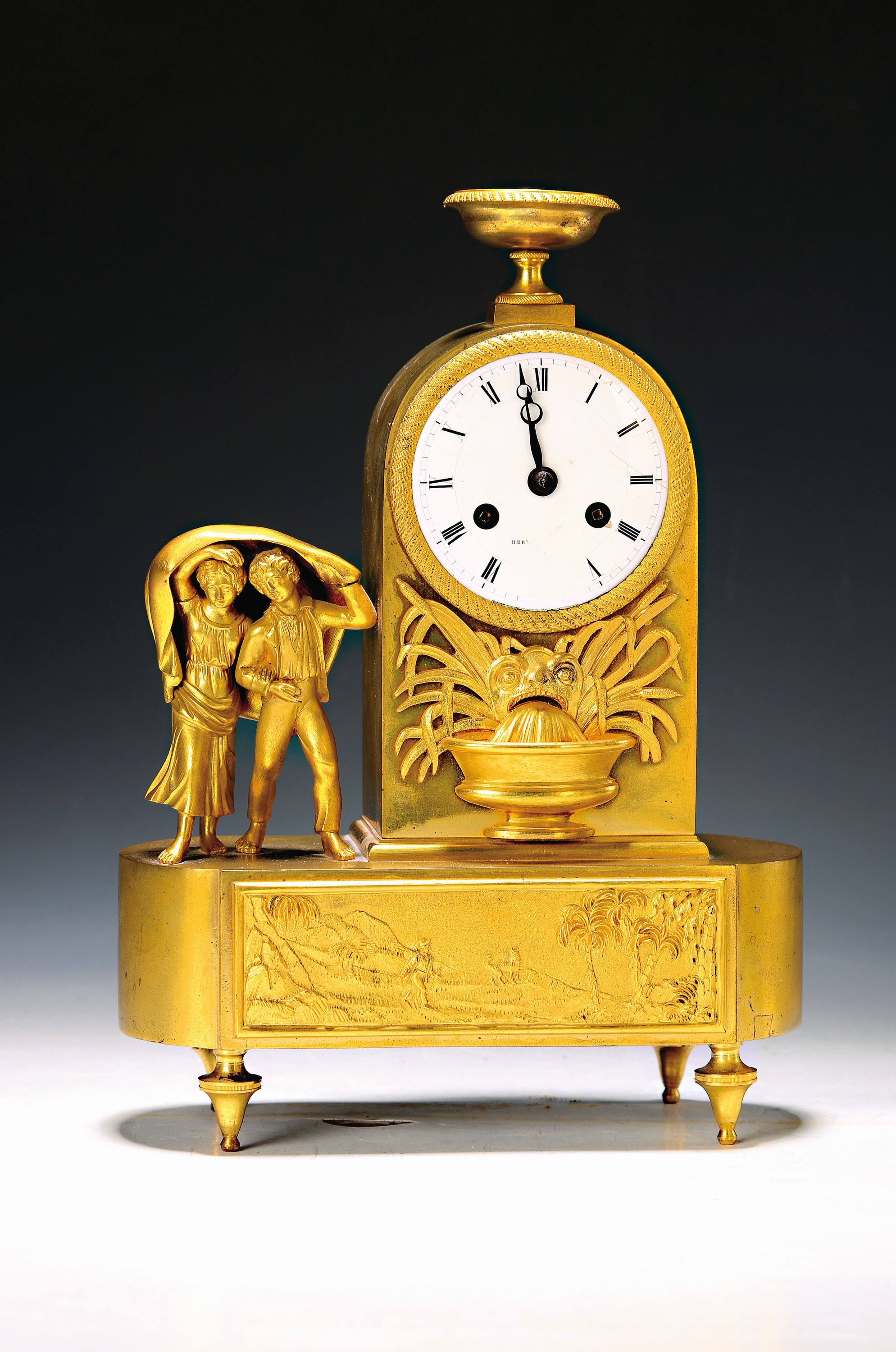 Kleine Pendule, Empire, Frankreich um 1810/20, Bronzegehäuse mit alter Vergoldung (ber.), im Sockel Wanderer mit Hund, flach reliefiert, neben Uhr ...