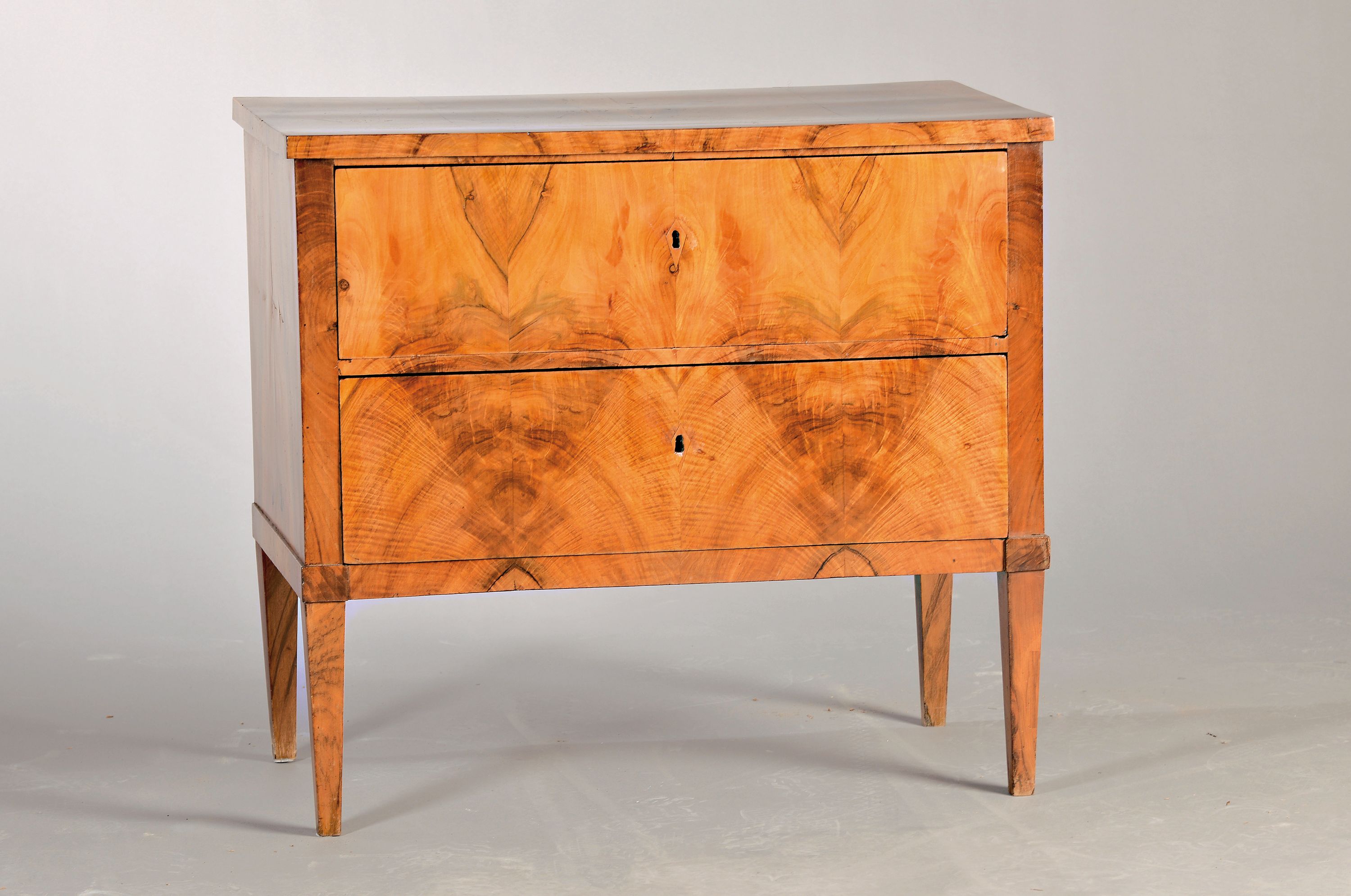 Kleine Biedermeier-Kommode, um 1830, Nußbaumfurnier, 2 Schubladen, auf spitzen Beinen, ca. 74x81x44 cm, EZ 2
