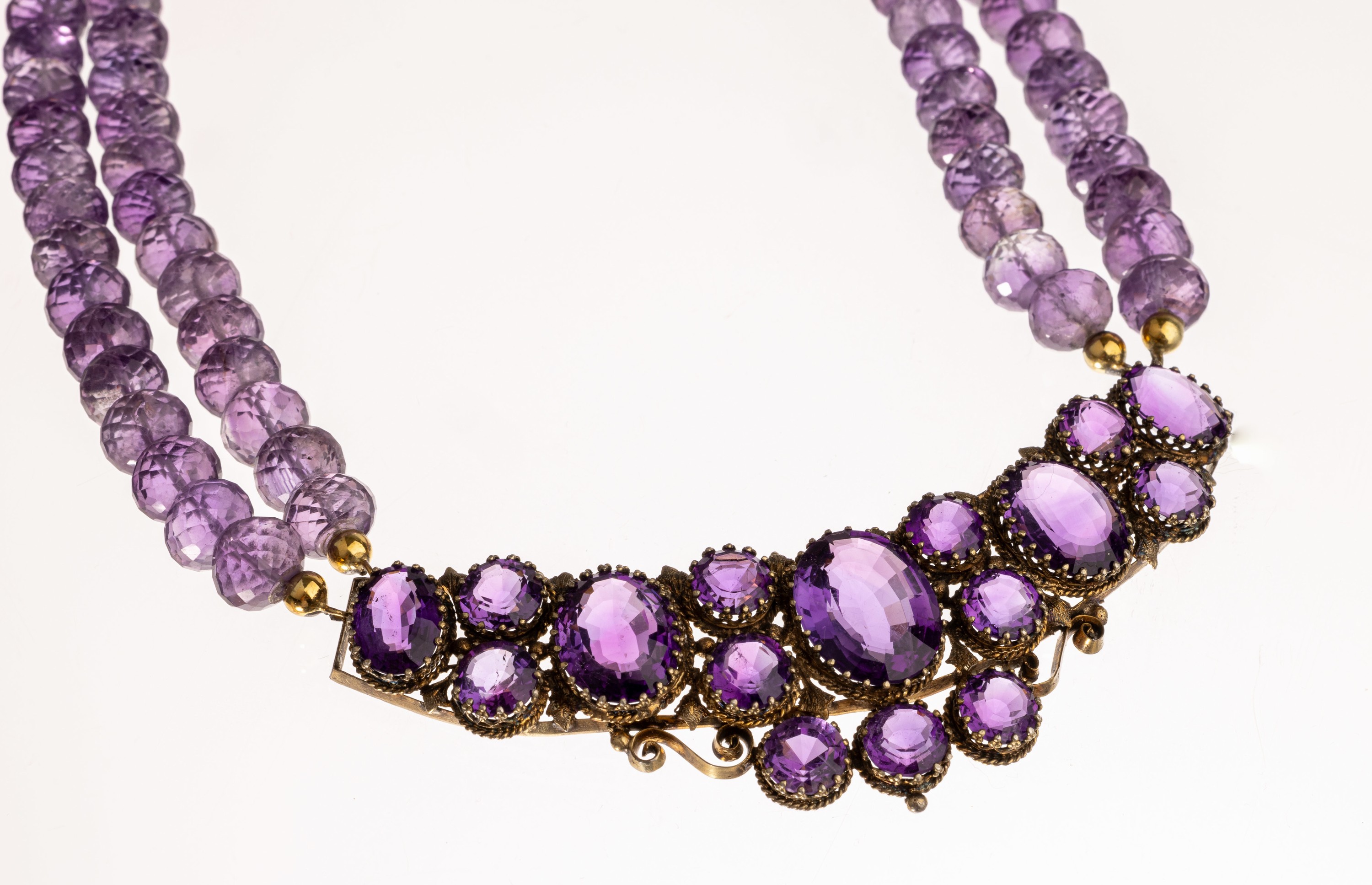 Detail a: Amethyst-Collier, Mittelteil um 1900, mit rund- und ovalfacett. Amethysten von sehr schöner Farbe, Fassung Metall verg., Kette 2- rhg. aus facett. ...