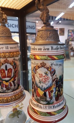 26768671b - 3 reservist steins, 2 of Baden Field Artillery Regiment No. 50 Karlsruhe, 1899-1905, tin lid crown changed/added and Baden Grenadier Regiment, Kaiser Wilhelm No. 110 Heidelberg, 1902-04, porcelain, polychrome lithographed and painted, lithophane in the base , tin lid with figurative attachment (2 are slightly damaged), traces of age, h. 27 cm