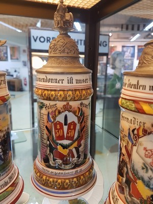 26768671c - 3 reservist steins, 2 of Baden Field Artillery Regiment No. 50 Karlsruhe, 1899-1905, tin lid crown changed/added and Baden Grenadier Regiment, Kaiser Wilhelm No. 110 Heidelberg, 1902-04, porcelain, polychrome lithographed and painted, lithophane in the base , tin lid with figurative attachment (2 are slightly damaged), traces of age, h. 27 cm