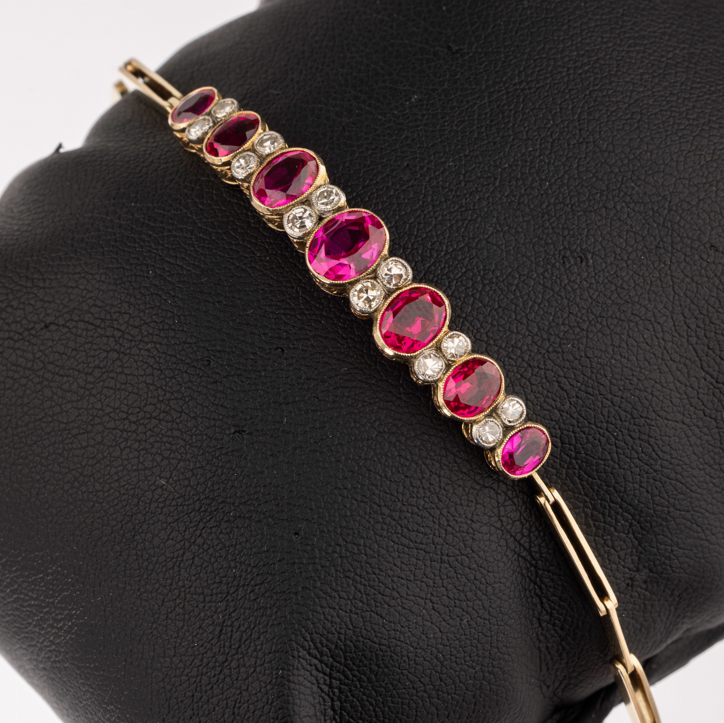 14 kt Gold Farbstein-Diamant-Armband, um 1910, GG 585/000, 7 ovalfacett. Rubin-Synthesen, 12 8/8-Diam. in schauseitig platinierten Fassungen zus. ca. ...