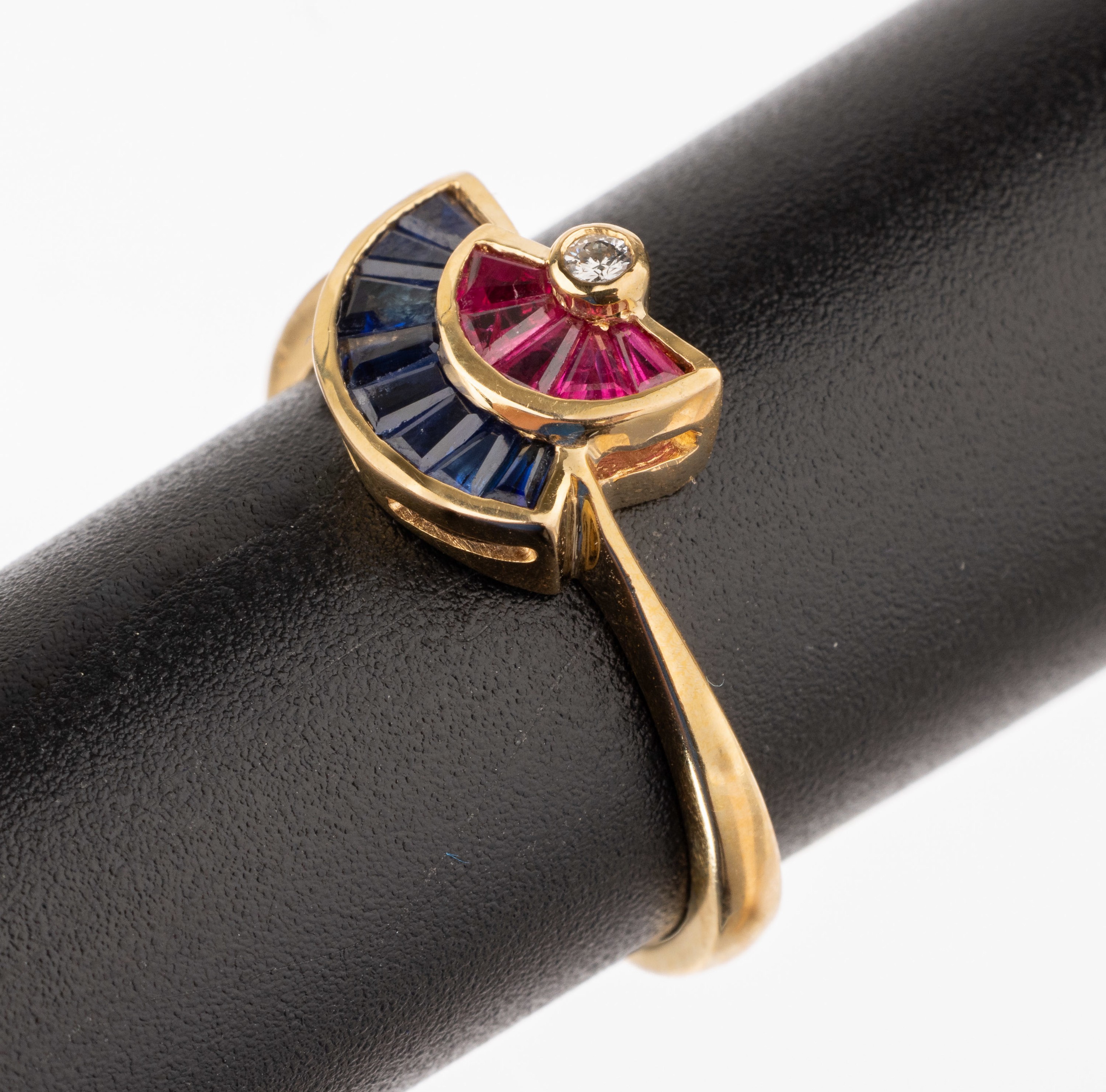 18 kt Gold Saphir-Rubin-Brillant-Ring, GG 750/000, 8 Saphir-Trapeze zus. ca. 0.16 ct, 5 eingeschliffene Rubine zus. ca. 0.10 ct, 1 Brillant ca. 0.02 ...