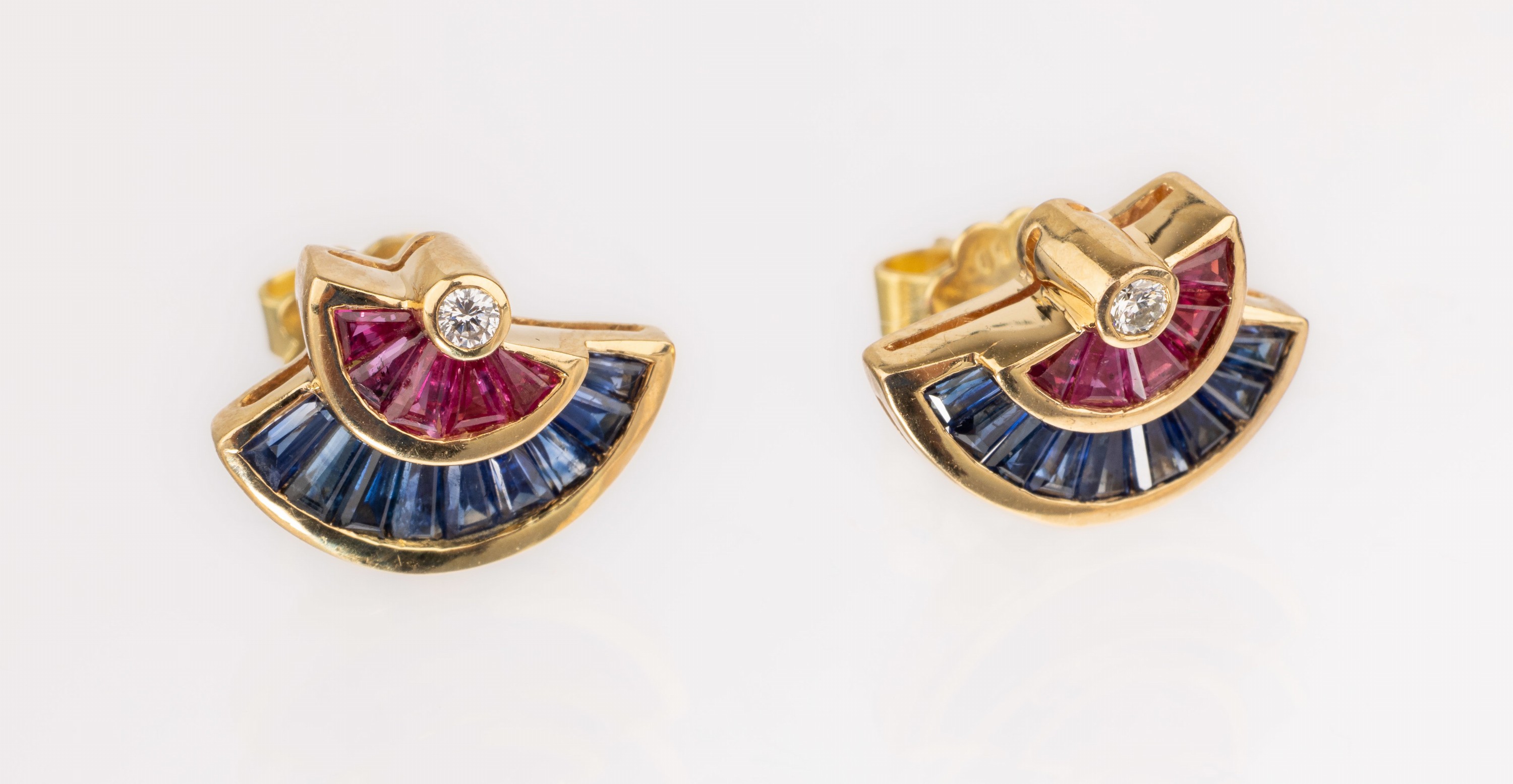 Paar 18 kt Gold Saphir-Rubin-Brillant -Ohrstecker, GG 750/000, 18 Saphir-Trapeze zus. ca. 0.32 ct, 10 eingeschliffene Rubine zus. ca. 0.20 ct, 2 ...