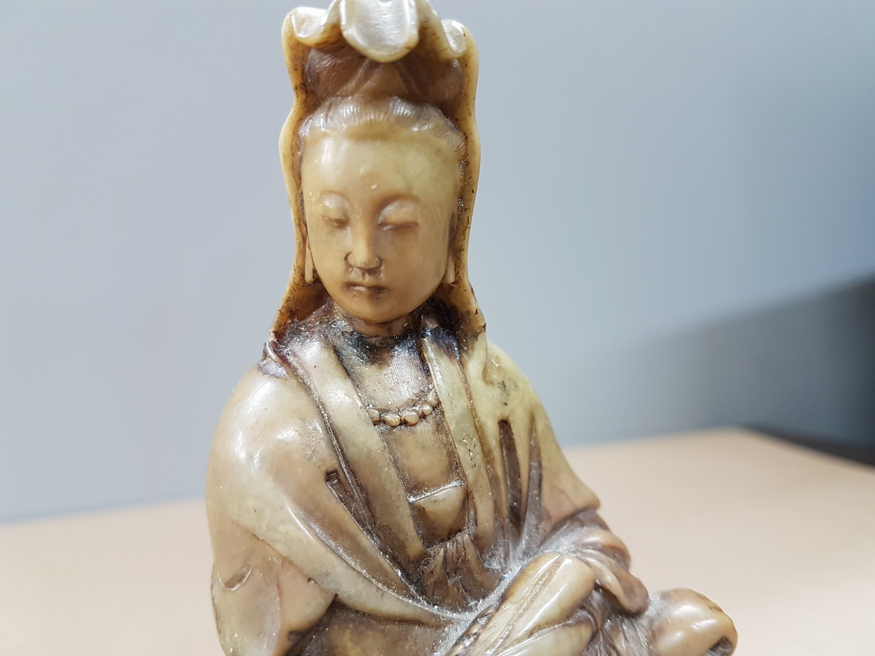 Detail e: Kannon aus Oka-Dera, Japan, 20. Jh., Stein, geschnitten, sitzender weiblicher Bodhisattva, H. 12,5 cm