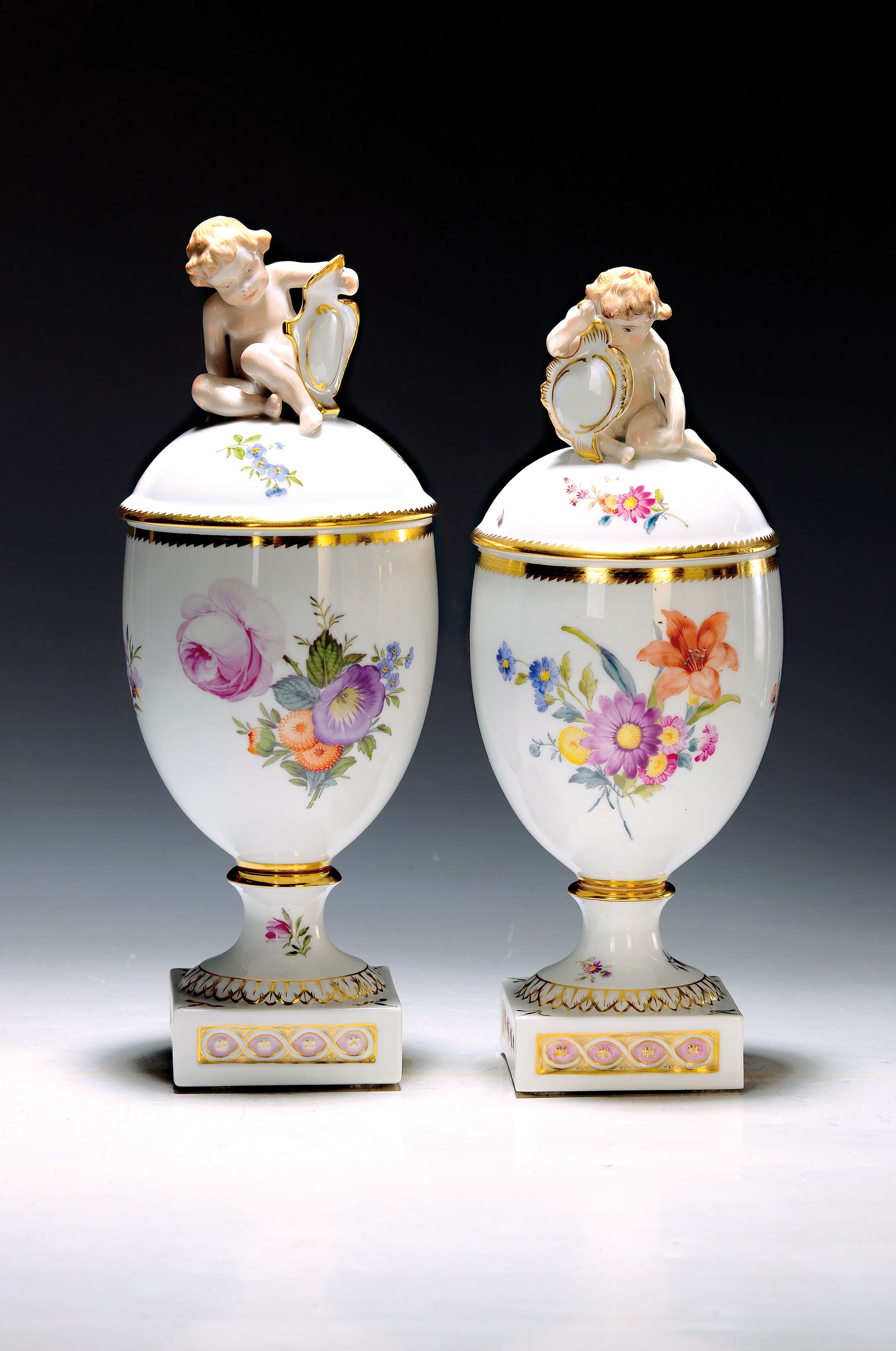 Paar Deckelvasen, Kgl. Kopenhagen, um 1900, Porzellan, feine bunte Blumenmalerei, Goldstaffage, Deckelbekrönungen in Form vollplastischer Amoretten ...