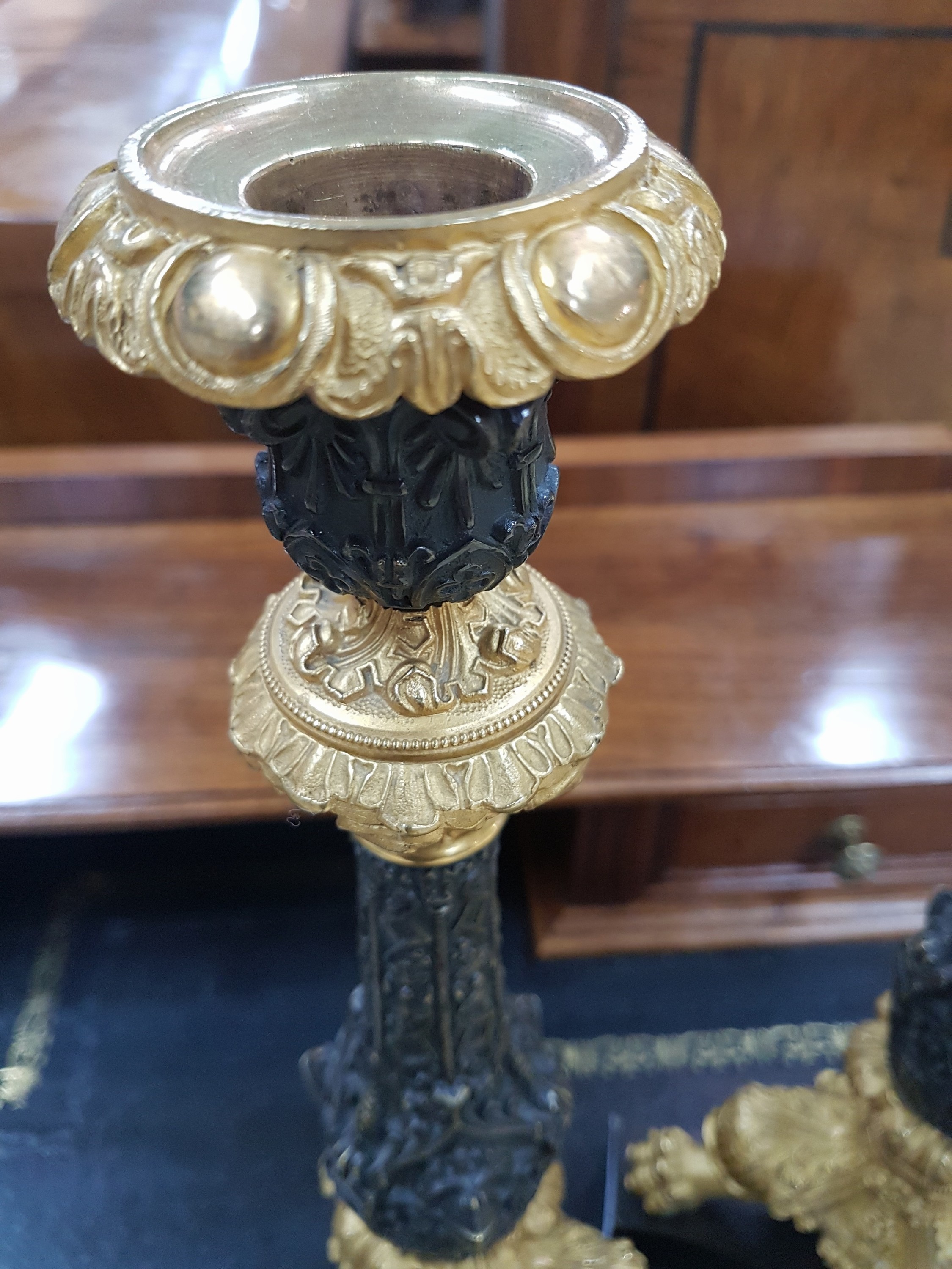 Detail c: Paar Kerzenleuchter, Frankreich, um 1820-30, reich reliefierter Bronzeguß z.T. vergoldet, auf drei Klauenfüßen stehend, Maskerone von Rittern, ...