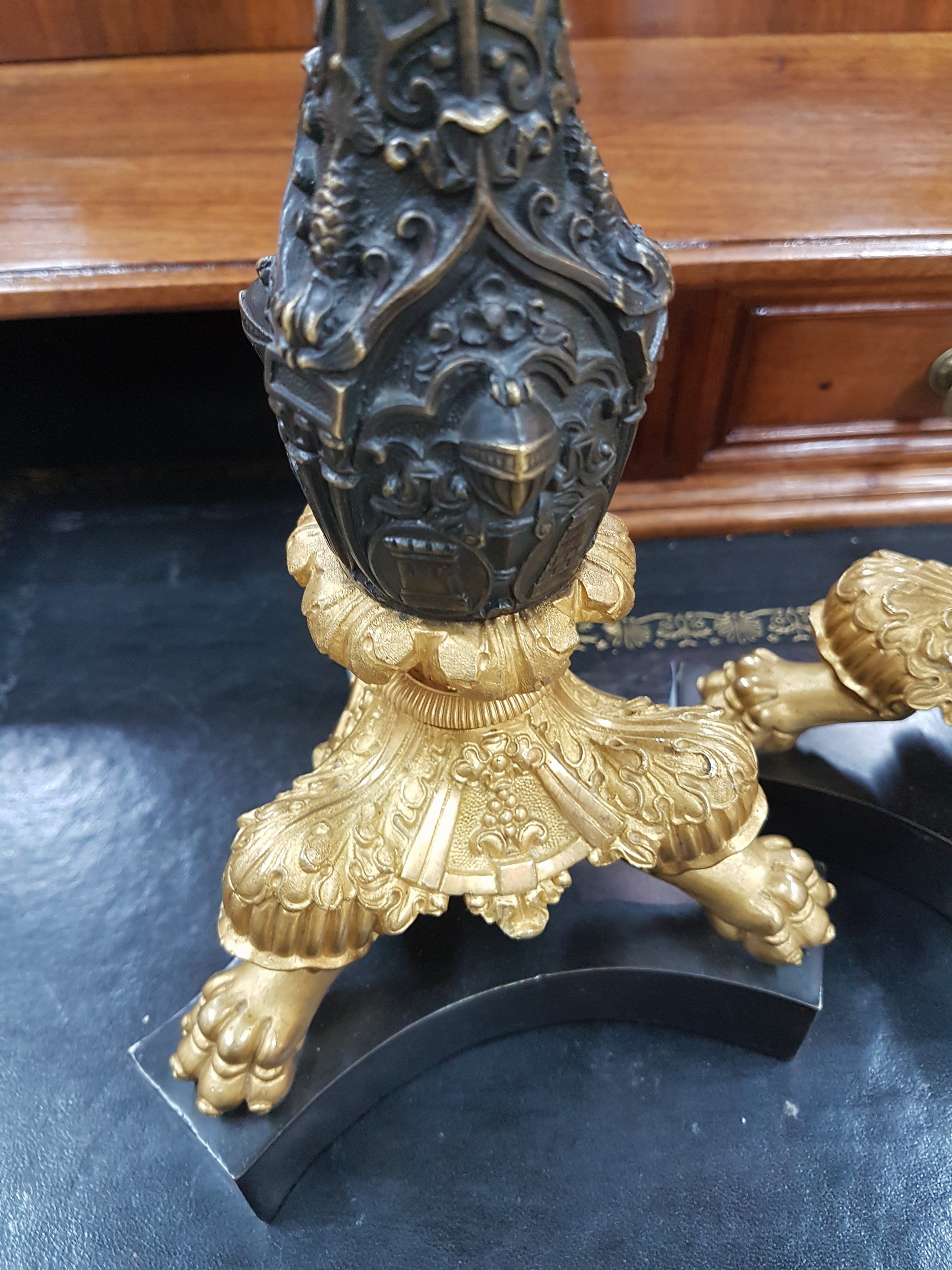 Detail d: Paar Kerzenleuchter, Frankreich, um 1820-30, reich reliefierter Bronzeguß z.T. vergoldet, auf drei Klauenfüßen stehend, Maskerone von Rittern, ...