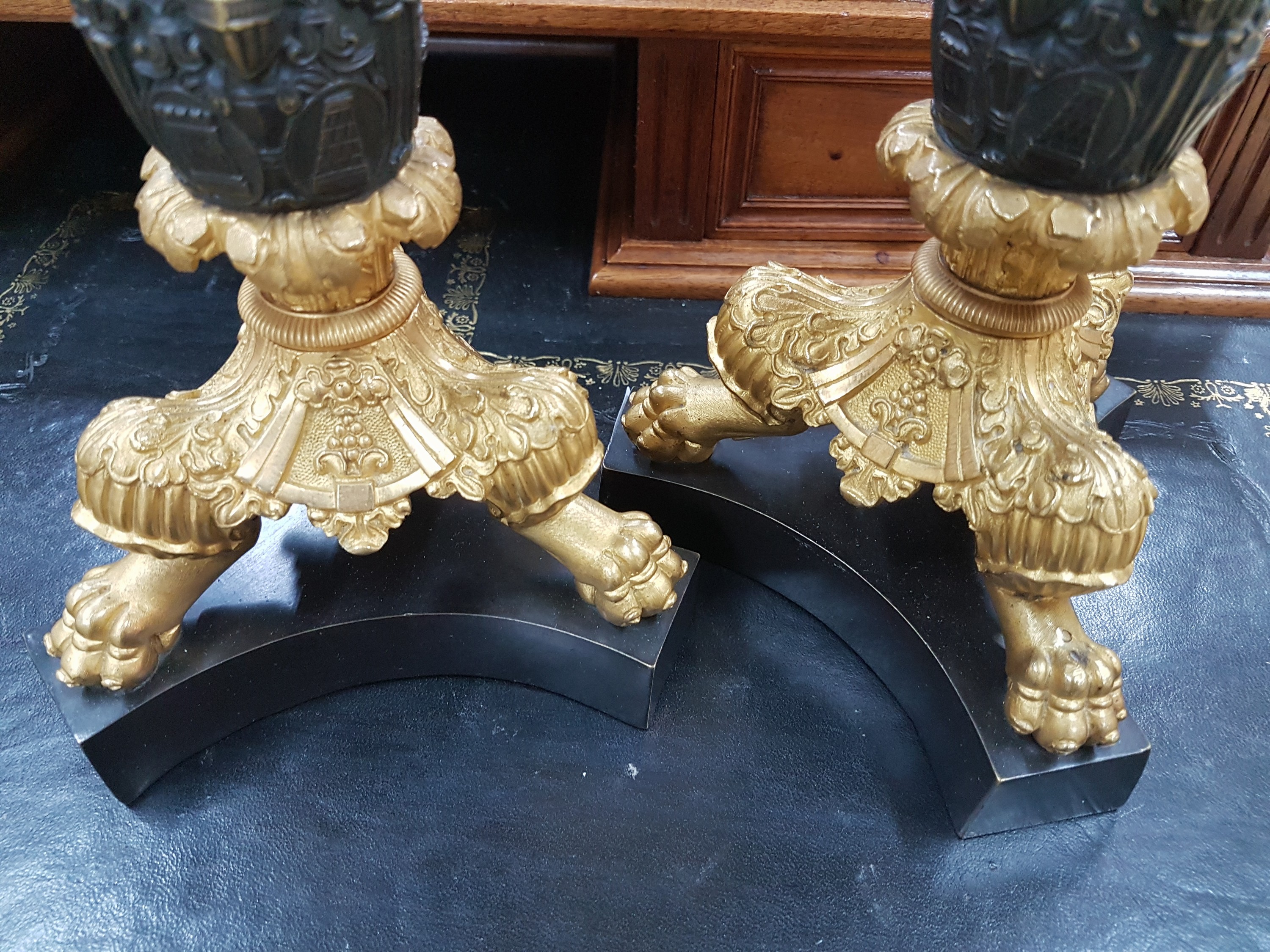 Detail f: Paar Kerzenleuchter, Frankreich, um 1820-30, reich reliefierter Bronzeguß z.T. vergoldet, auf drei Klauenfüßen stehend, Maskerone von Rittern, ...
