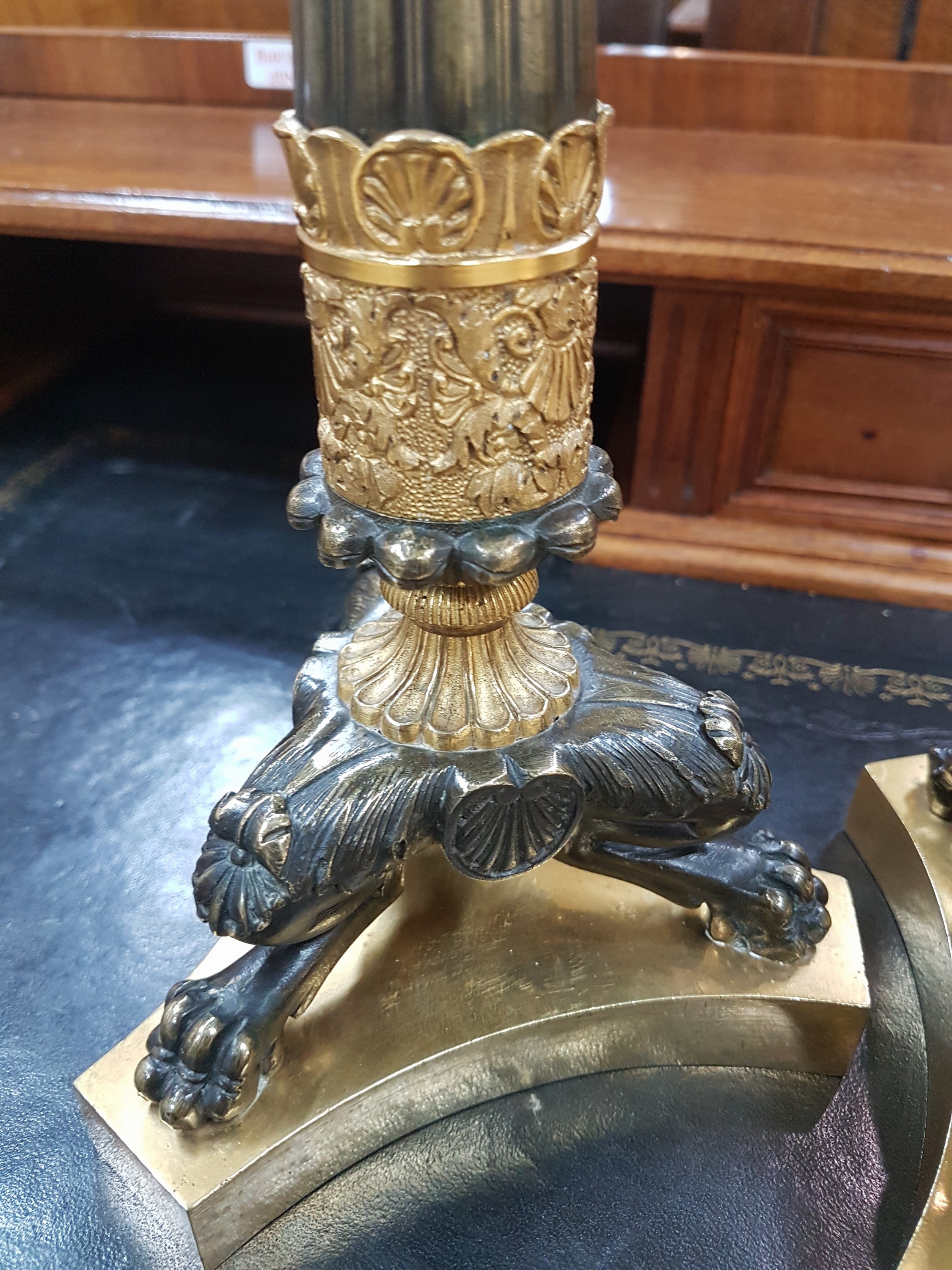 Detail c: Paar Kerzenleuchter, Frankreich, um 1820-30, reich reliefierter Bronzeguß z.T. vergoldet, auf drei Klauenfüßen stehend, kannelierte Säulen mit ...