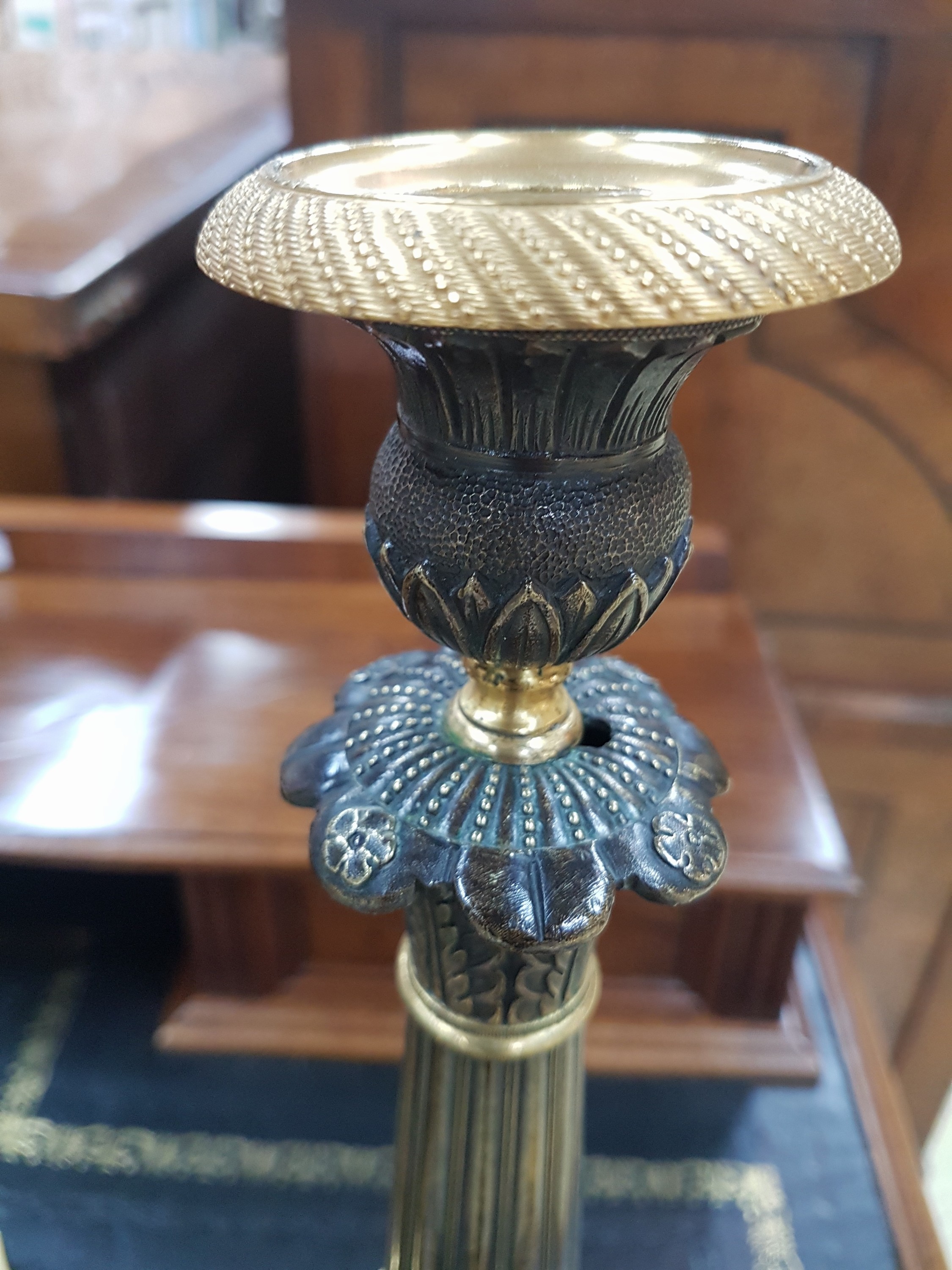Detail d: Paar Kerzenleuchter, Frankreich, um 1820-30, reich reliefierter Bronzeguß z.T. vergoldet, auf drei Klauenfüßen stehend, kannelierte Säulen mit ...