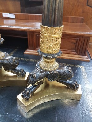 26769232b - Pair of candlesticks, France, around 1820-30, cast bronze with rich relief, partly gilded, standing on three claw feet, fluted columns with acanthus and palmette decoration, height approx. 33cm each