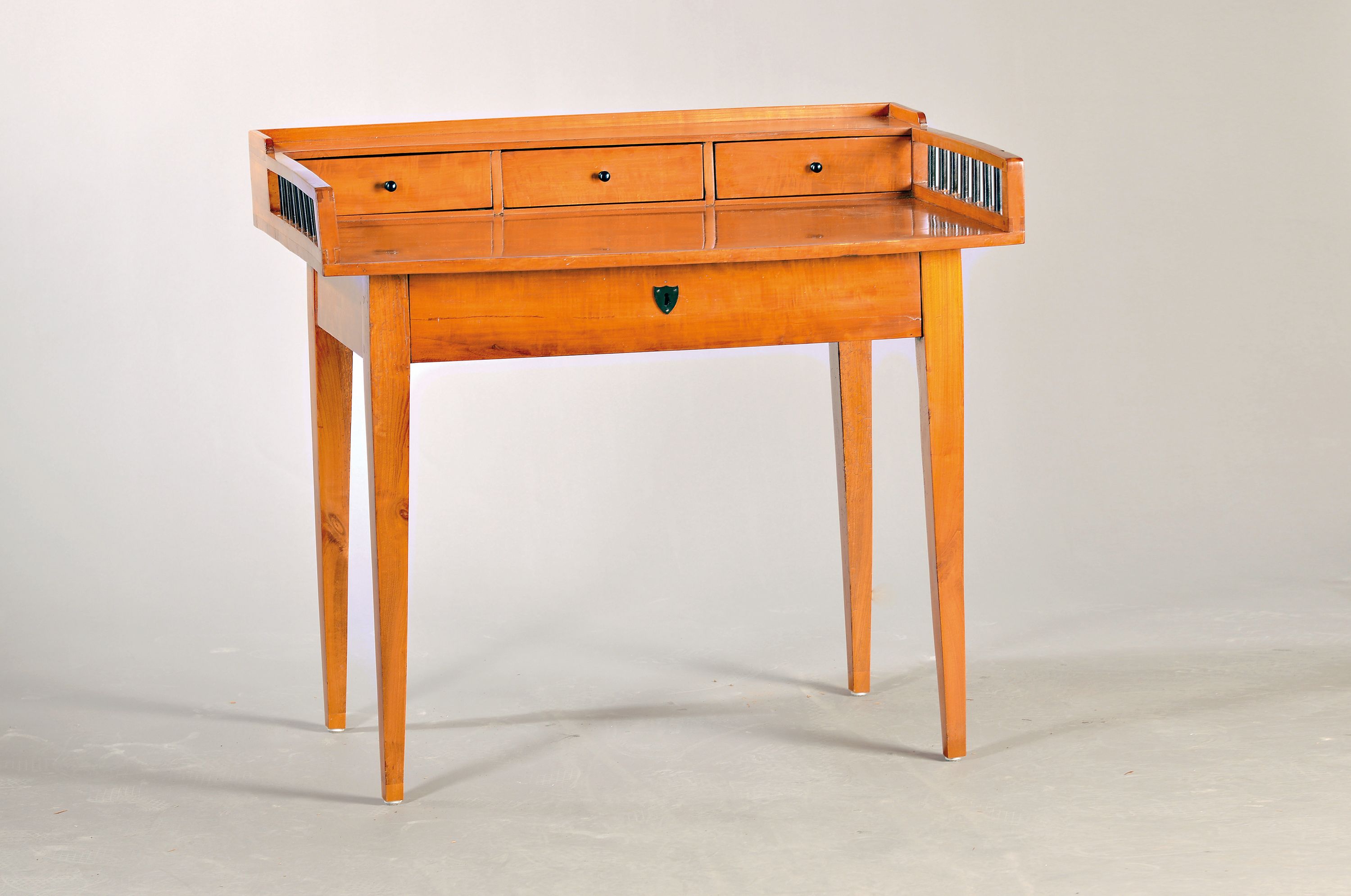 Schreibtisch, im Biedermeier-Stil, 20.Jh., Birnenfurnier, eine Schublade, Schreibplatte mit 3 Schubladen und Galerie, ohne Schlüssel, ca. 87x97x62 ...