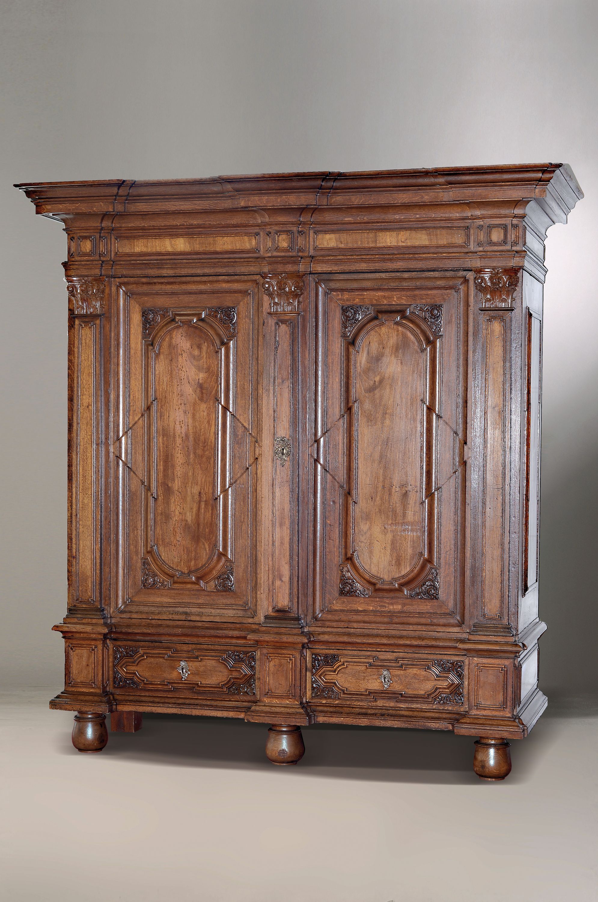 Barockschrank/Pilasterschrank, wohl Braunschweig, um 1720, Nußbaumfurnier auf Eichekorpus, Schnitzereien und Profile in Eiche massiv, Front mit 3 ...