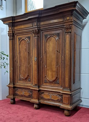 26770581h - Baroque cupboard/pilaster cupboard, probably Brunswick, around 1720, walnut veneer on oak body, carvings and profiles in solid oak, front with 3 pilasters and Corinthian capitals, cornice and base double cranked, doors and sides with cushion fillings, base with 2 drawers, orig. Locks, door with orig. Locomotive, original key and original Brass fittings, approx. 228 x 208 x 78 cm, condition 2