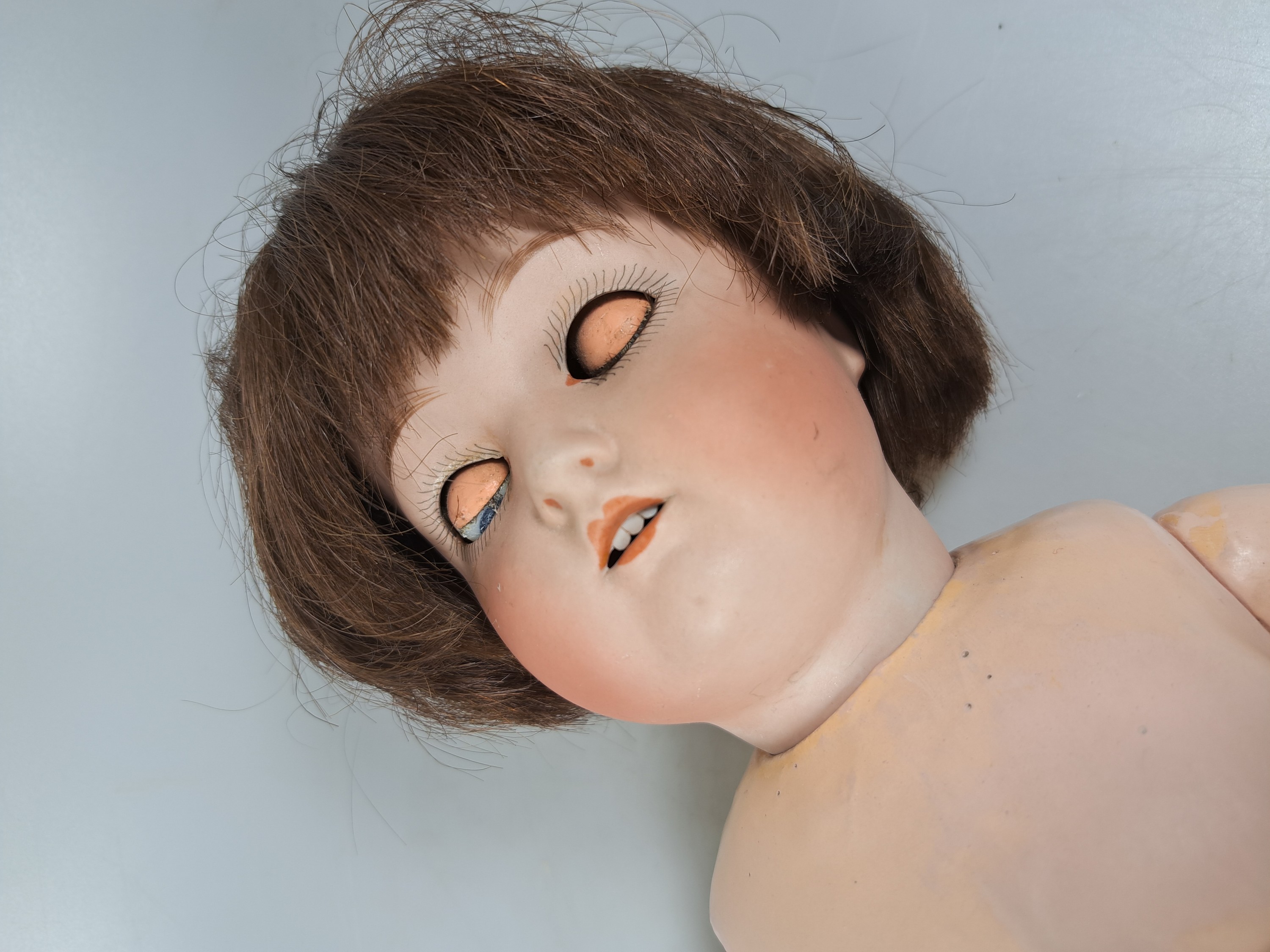 Detail d: Zwei Porzellankopfpuppe, 1x Wagner & Zetsche, Kopfmarke 8 1/2, W & Z J, um 1920, Kurbelkopf, offener Mund, ein Zähnchen fehlt, braune Perücke, ...