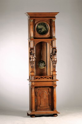 Image 26771993 - Grandfather clock, around 1900, decorated wooden case, historicism with Art Nouveau influences, central swing area of the pendulum, flanked by a fully sculpted caryatidand atlases, wooden case richly profiled with fluting, wooden bezel (left with stress cracks), richly decorated brass dial with stylized cartouches, symbolic wheel in the middle (passing of time), decorated hands, brass plate movement No. 1533403, 2 weights inthe style of the clock, pendulum disc in Art Nouveau-style, half-hour strike on round gong,drive via 2 chains and weights (chains are loose), at the top 2 on the side Observation door, height approx. 222cm, condition of movement 2-3 (= good condition with minor flaws), housing 2, magnificent, rare