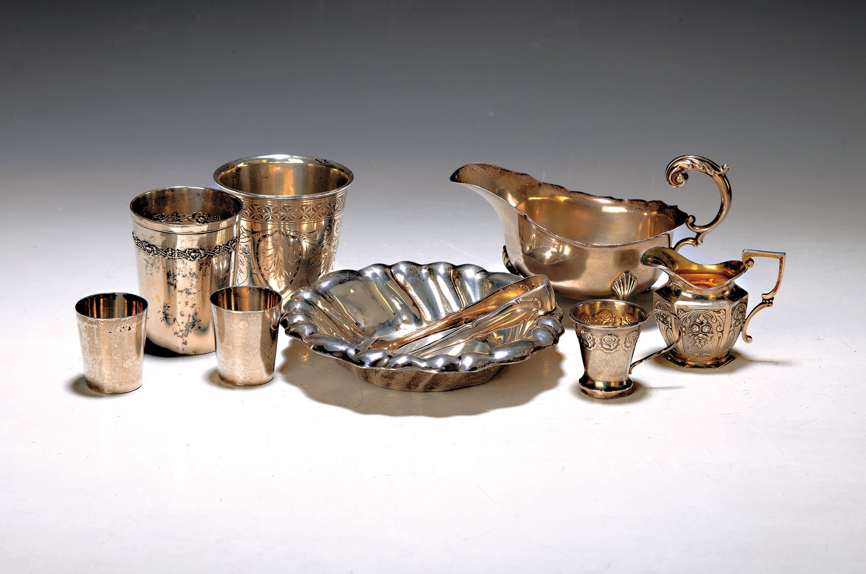 9 Teile Silber-Tafelzubehör, um 1900 und erste Hälfte 20. Jh., vier Becher, kl. Schälchen, kl. englische Sauciere, kl. Sahnegießer, Zuckerzange, ...