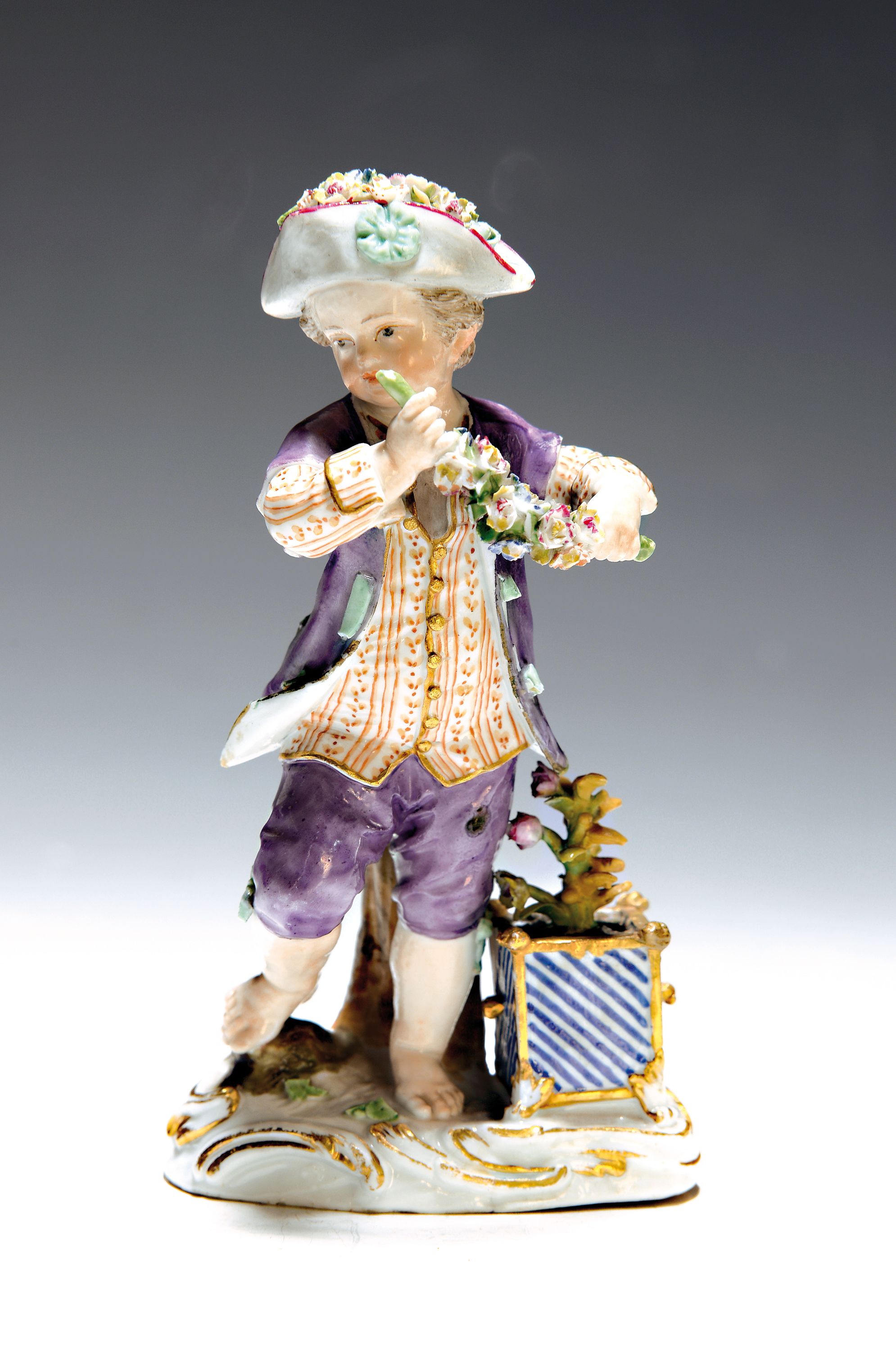 Frühe Porzellanfigur, Meissen, 18. Jh., Gärtner mit Blumengirlande, applizierte Blümchen, daneben Rosenstock im Topf, Goldstaffage, H. ca. 14 cm, ...
