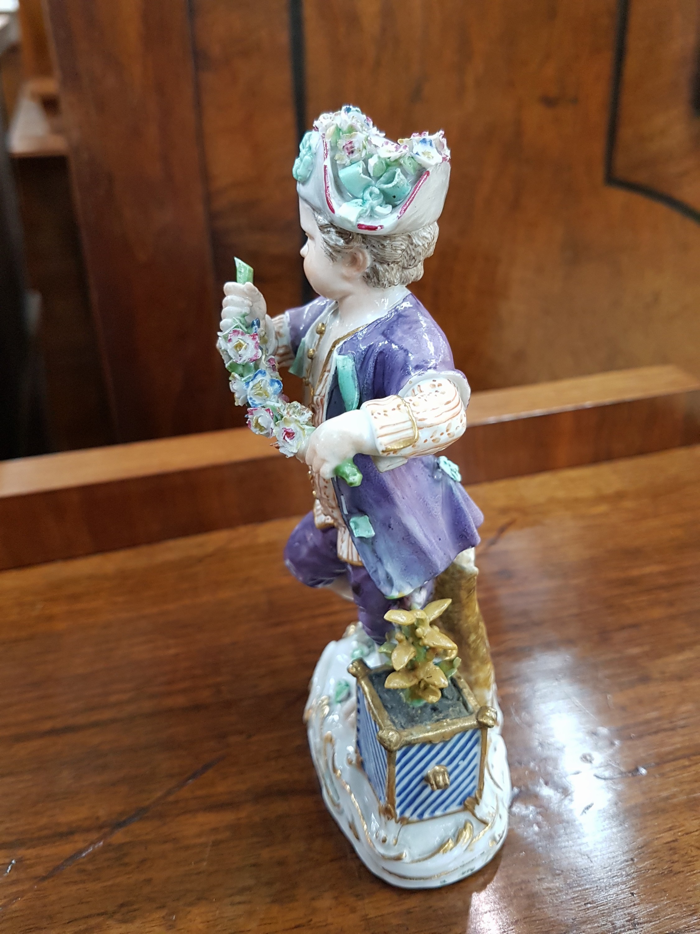 Detail d: Frühe Porzellanfigur, Meissen, 18. Jh., Gärtner mit Blumengirlande, applizierte Blümchen, daneben Rosenstock im Topf, Goldstaffage, H. ca. 14 cm, ...