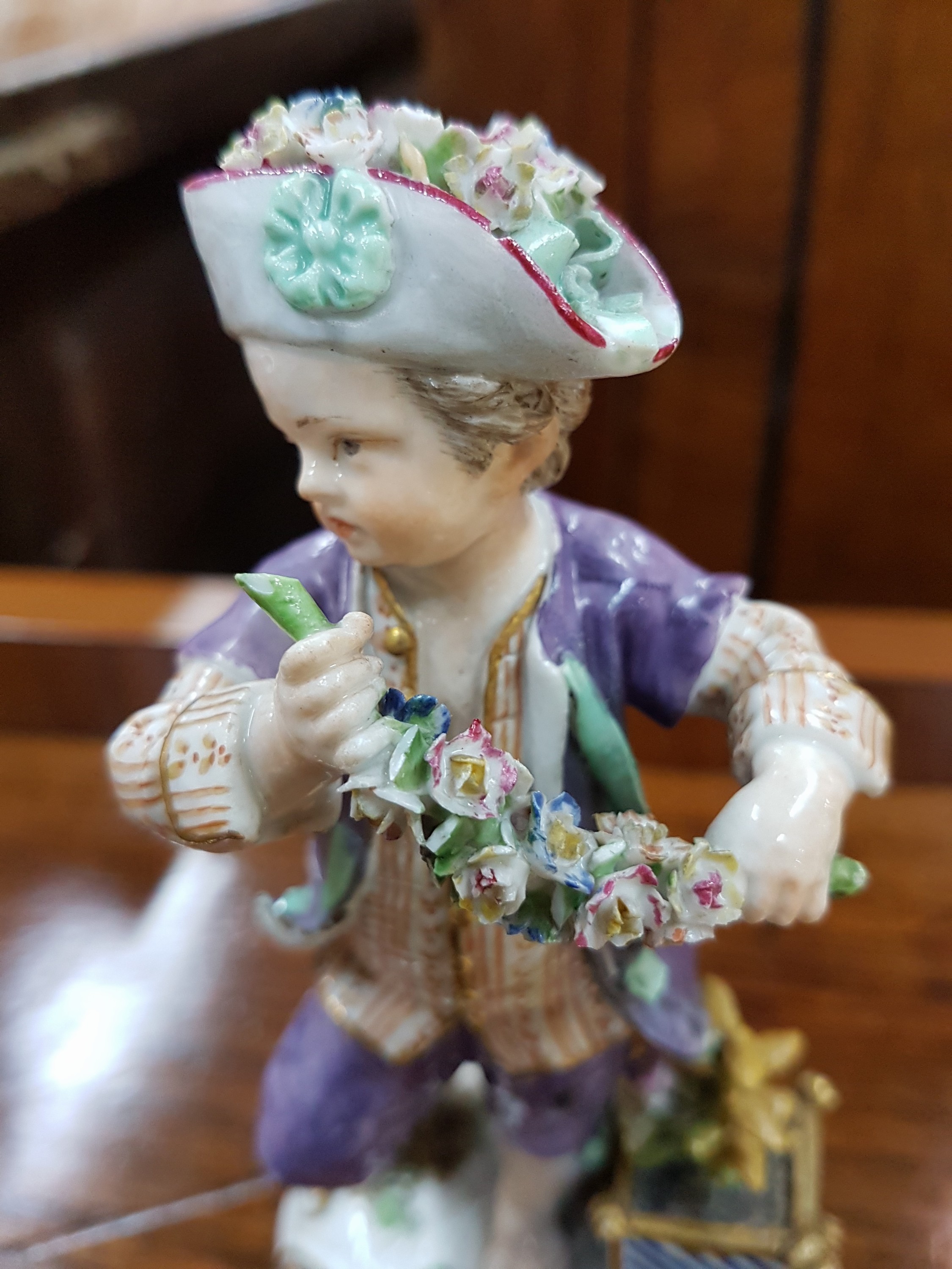 Detail e: Frühe Porzellanfigur, Meissen, 18. Jh., Gärtner mit Blumengirlande, applizierte Blümchen, daneben Rosenstock im Topf, Goldstaffage, H. ca. 14 cm, ...