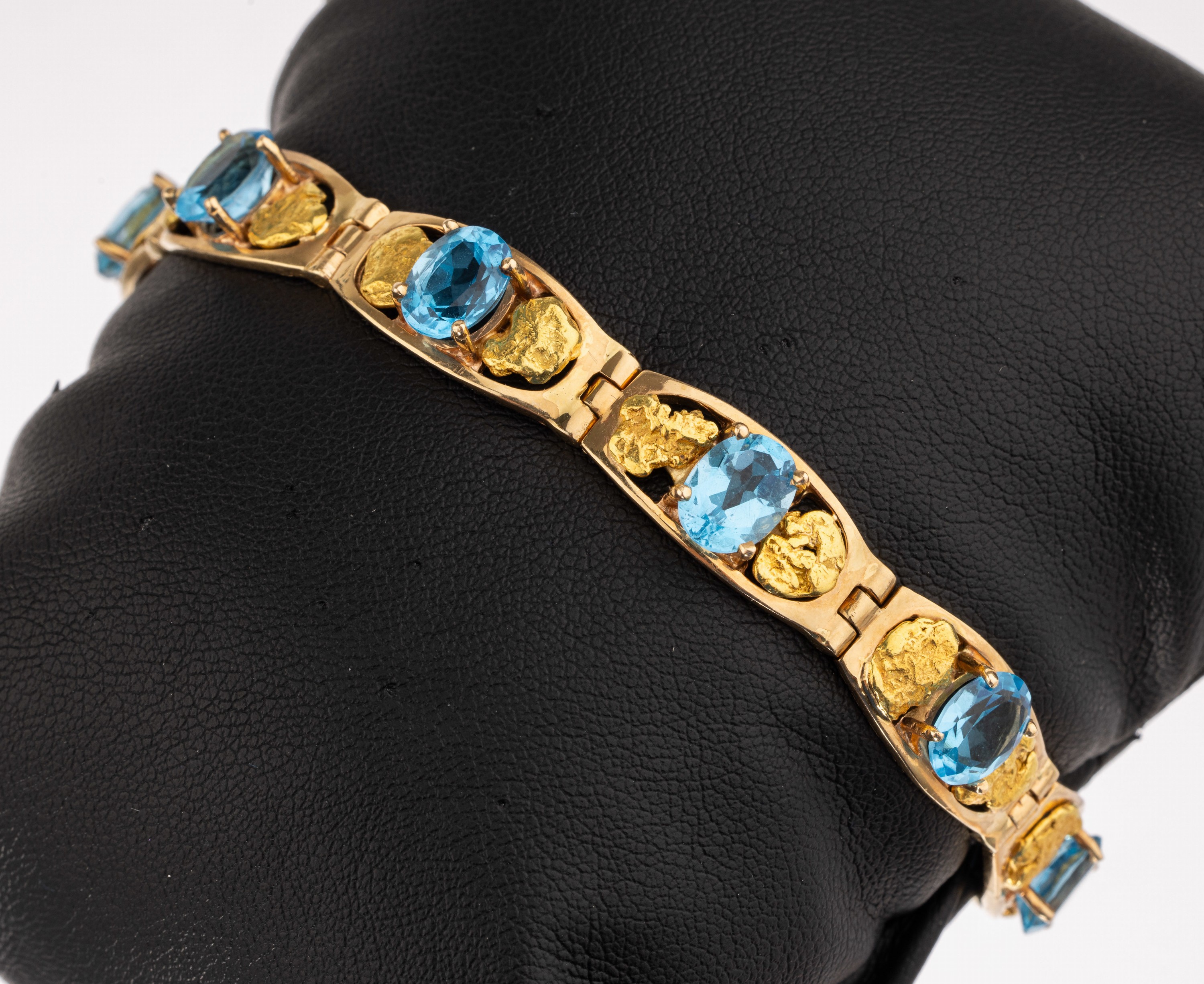 14 kt Gold Blautopas Armband, RG/GG 585/ 000, ovale bewegl. Elemente bes. mit 8 Blau- topase (beh.) zus. ca. 12.0 ct, mit nugget- förmigen GG ...