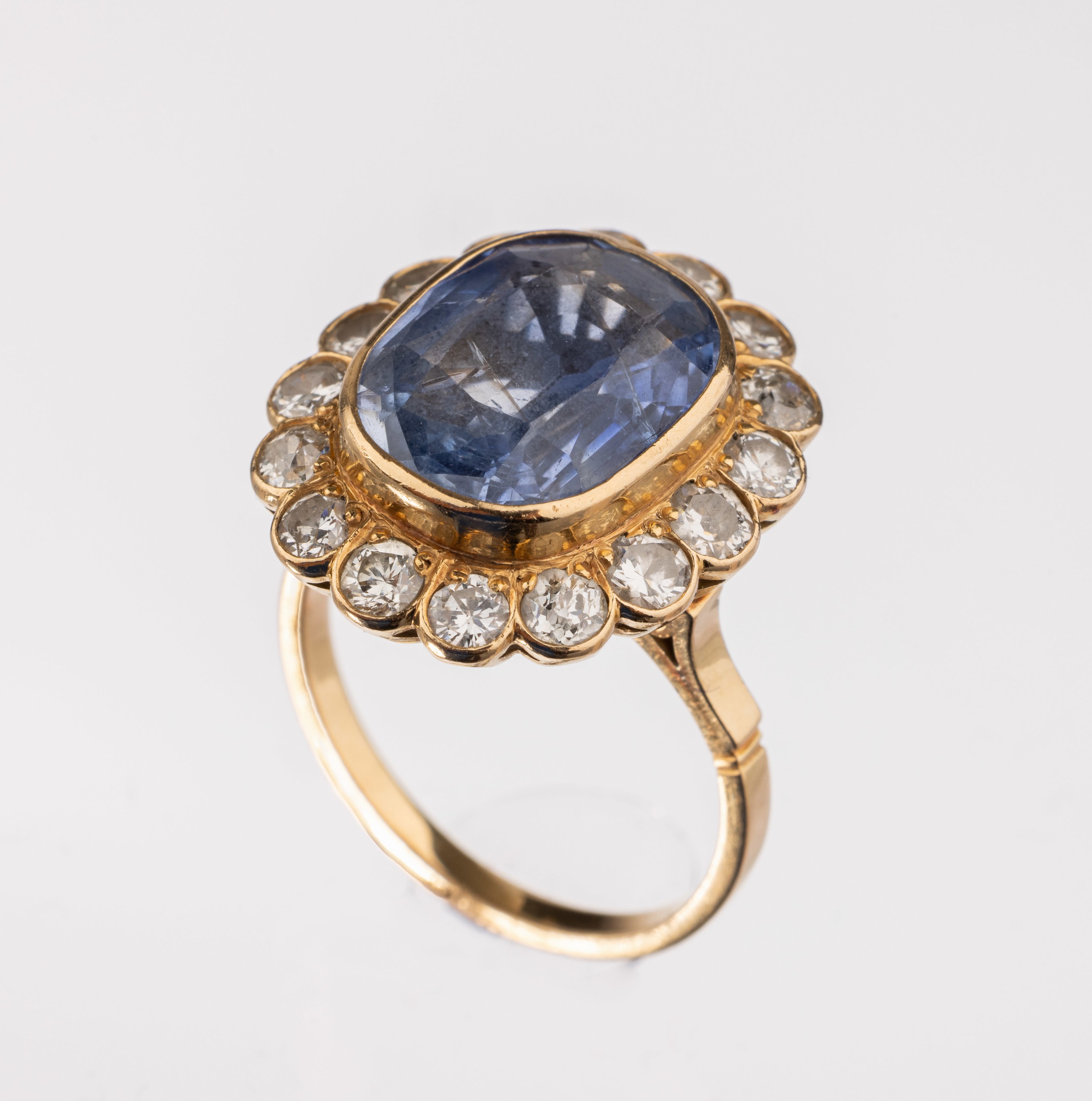 18 kt Gold Saphir Diamant Ring, nach 1920/ 1930, GG 750/000 gepr., facett. Saphir ca. 14.0 ct, umgeben von 16 Altschliff-Diamanten bzw. Brillanten ...