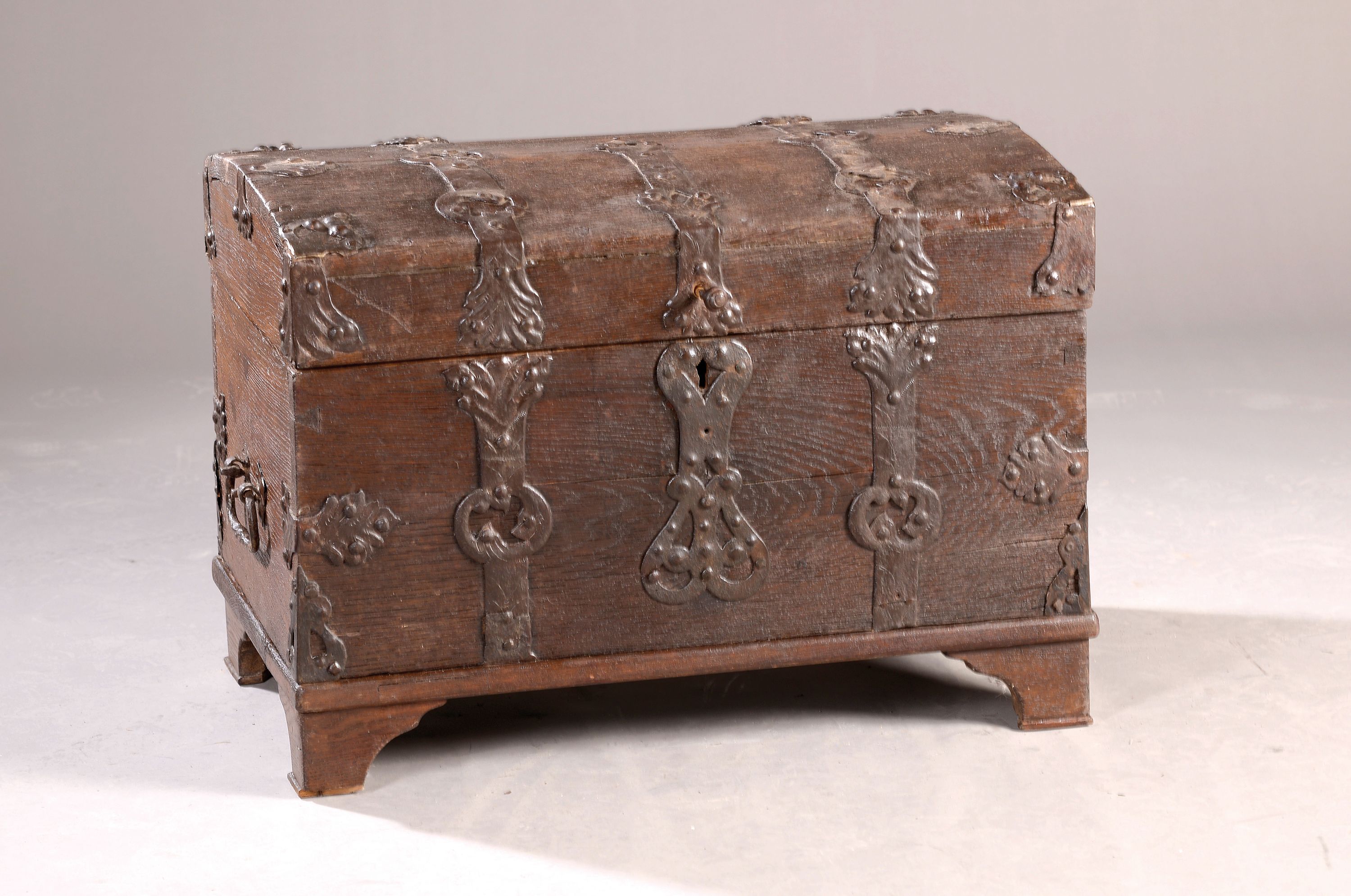 Kleine Barock-Truhe, um 1750, Eiche massiv, Runddeckelkorpus, schmiedeeisernes Beschlagwerk, org. Schloss, 1 Schlüssel, ca. 47x62 cm, EZ 2