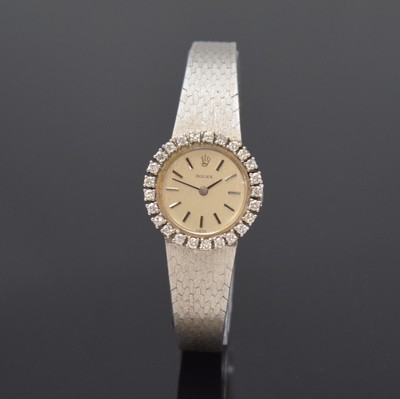 Image 26774554 - ROLEX 18k white gold and diamonds set ladies wristwatch, Switzerland 1960´s, manual winding, snap on case back, original gold bracelet, bezel lavish set with diamonds, silvered dial with raised hour-indices, black hands, calibre 1400, 18 jewels, diameter approx. 23 mm, length approx. 17 cm, total weight approx. 45g, glass damaged, overhaul recommended at buyer's expense, condition 2