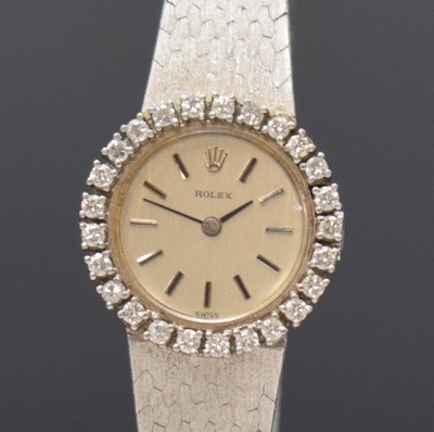 26774554a - ROLEX 18k white gold and diamonds set ladies wristwatch, Switzerland 1960´s, manual winding, snap on case back, original gold bracelet, bezel lavish set with diamonds, silvered dial with raised hour-indices, black hands, calibre 1400, 18 jewels, diameter approx. 23 mm, length approx. 17 cm, total weight approx. 45g, glass damaged, overhaul recommended at buyer's expense, condition 2