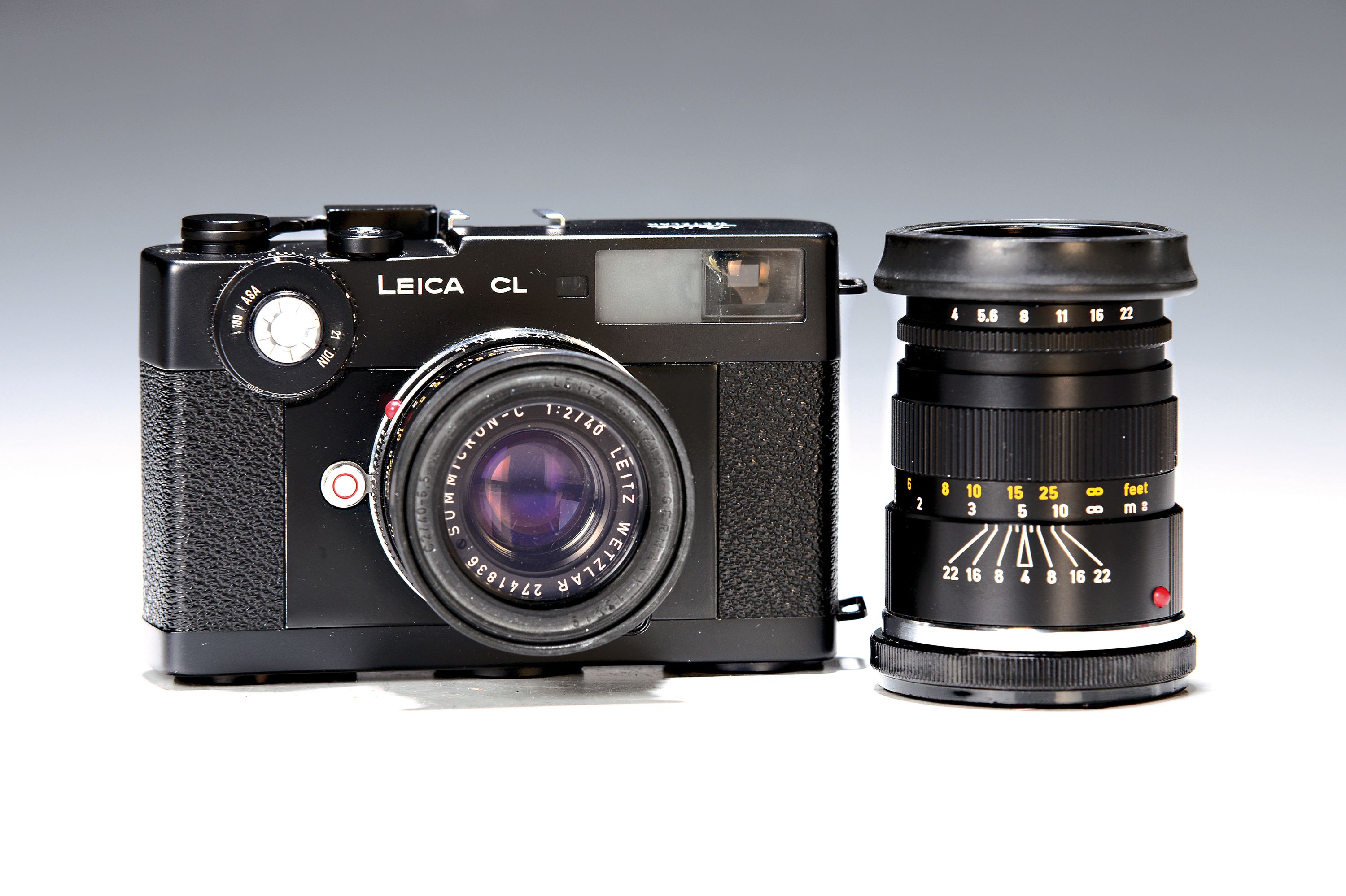 Leica CL, Bj. 1974/75, mit zwei Objektiven und orig. Unterlagen, Seriennr. 1408874, schwarzer Body, Glas vor Beleuchtungs- /Sucherfenster gesprungen, ...