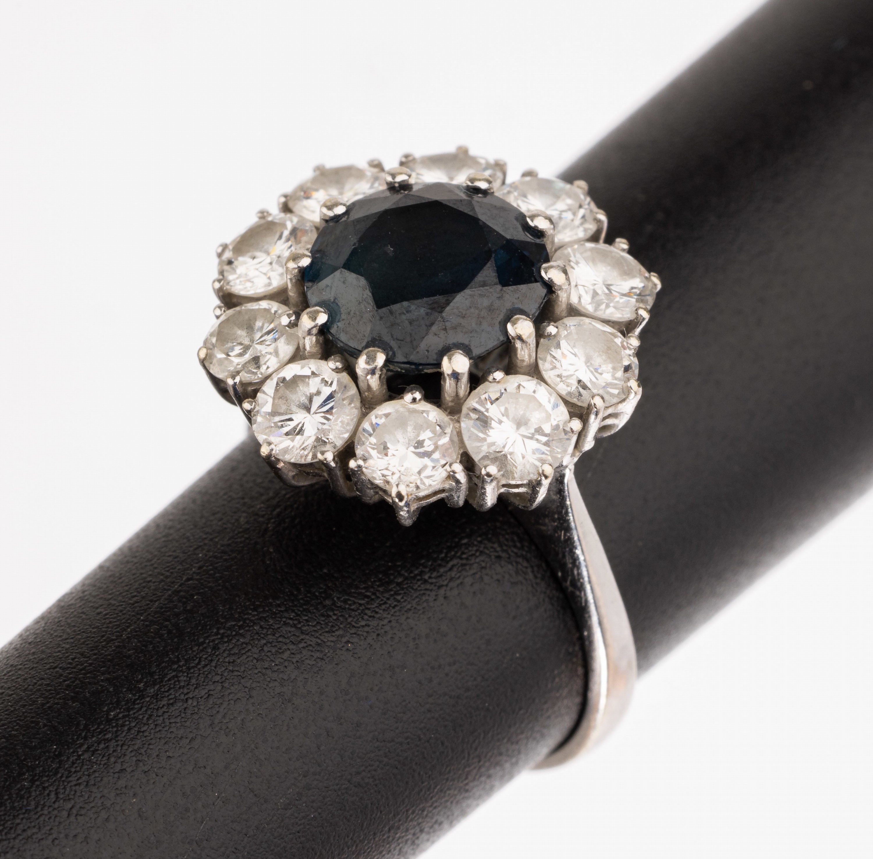 18 kt Gold Saphir Brillant Ring, WG 750/000, rundfacett. Saphir ca. 2.20 ct umgeben von 10 Brillanten zus. ca. 1.80 ct Weiß/si, RW 46, ca. 4.5 g