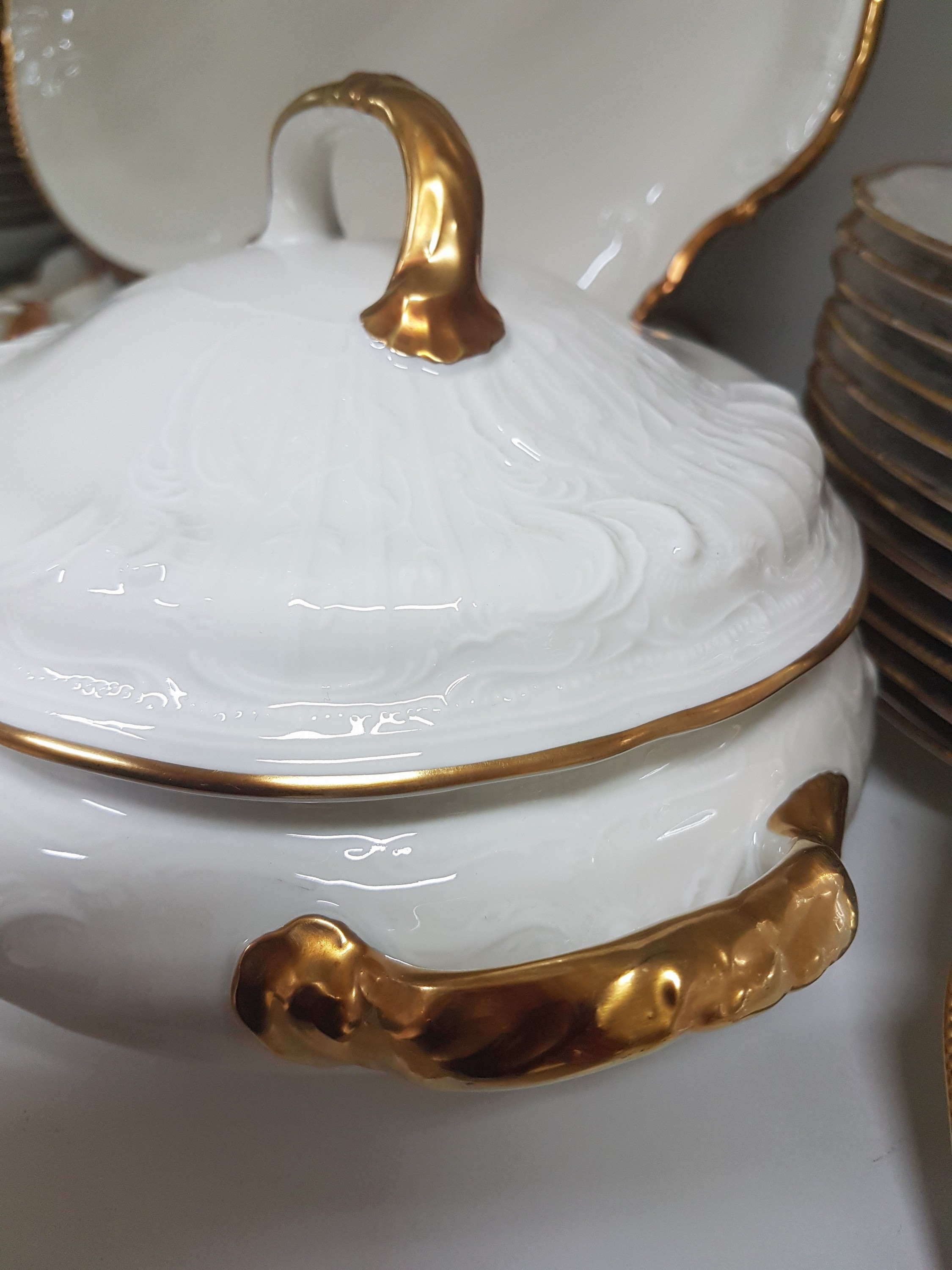 Detail e: Speiseservice, Rosenthal, Sanssouci, 20.Jh., Porzellan, Goldrand, Fahne mit Muschelwerk im Relief, 12 Speiseteller D. 25cm, 12 Suppenteller D. 24cm, ...