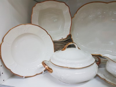 26777912c - Dinner service, Rosenthal, Sanssouci, 20th century, porcelain, gold rim, flag with shell work in relief, 12 dinner plates D. 25cm, 12 soup plates D. 24cm, 12 bread plates D. 20.5cm, 2 lidded tureens, 2 rectangular bowls, gravy boat, 3 different sized plates, traces of age, partly slightly rubbed