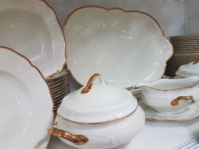 26777912d - Dinner service, Rosenthal, Sanssouci, 20th century, porcelain, gold rim, flag with shell work in relief, 12 dinner plates D. 25cm, 12 soup plates D. 24cm, 12 bread plates D. 20.5cm, 2 lidded tureens, 2 rectangular bowls, gravy boat, 3 different sized plates, traces of age, partly slightly rubbed