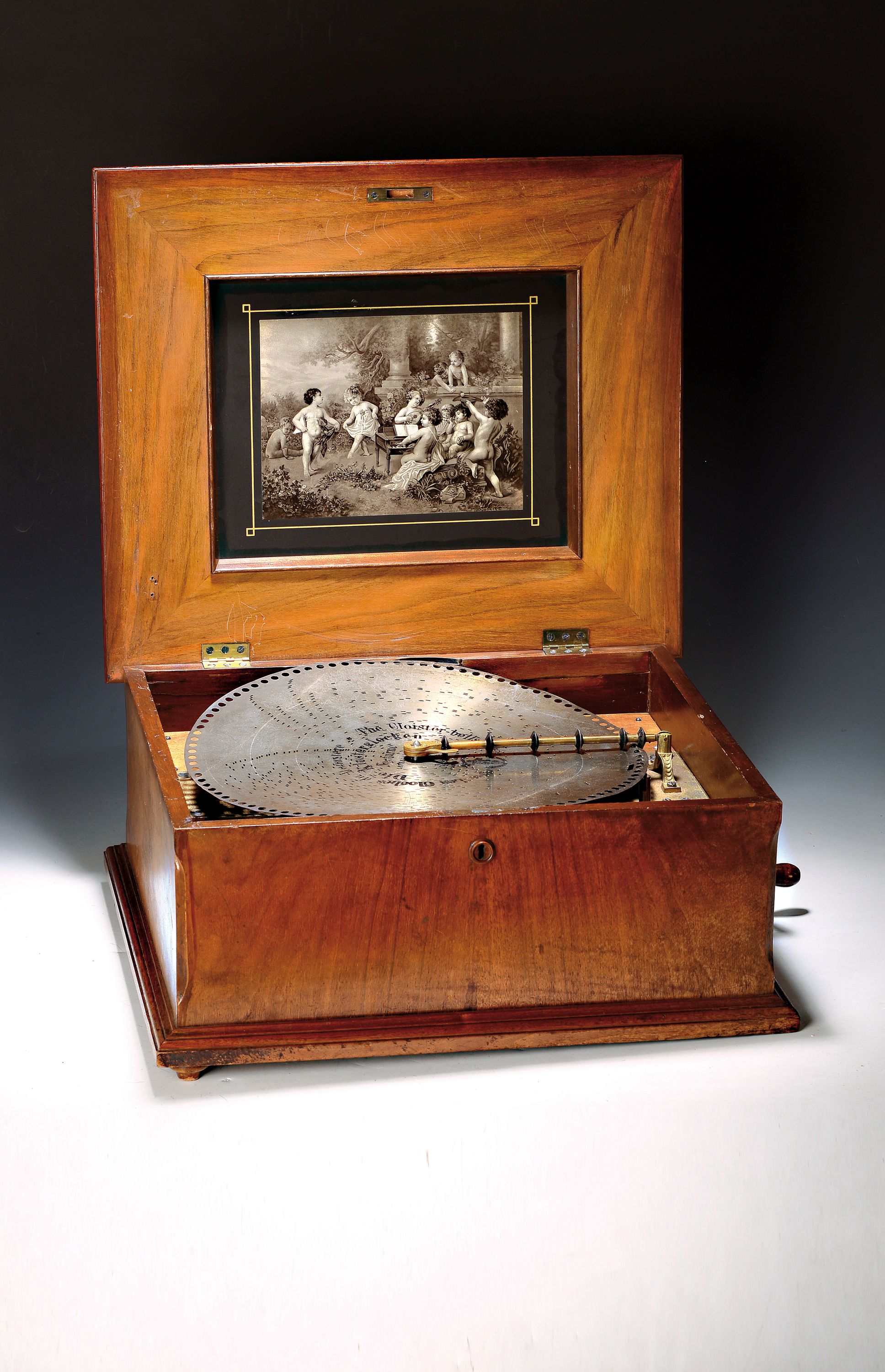 Großes Polyphon/Lochblechplattenspieluhr, Leipzig um 1900, Gehäuse Nussbaumfurnier, mit Kurbel und 15 Platten, D. 40 cm, Deckel mit Blumeneinlagen, ...