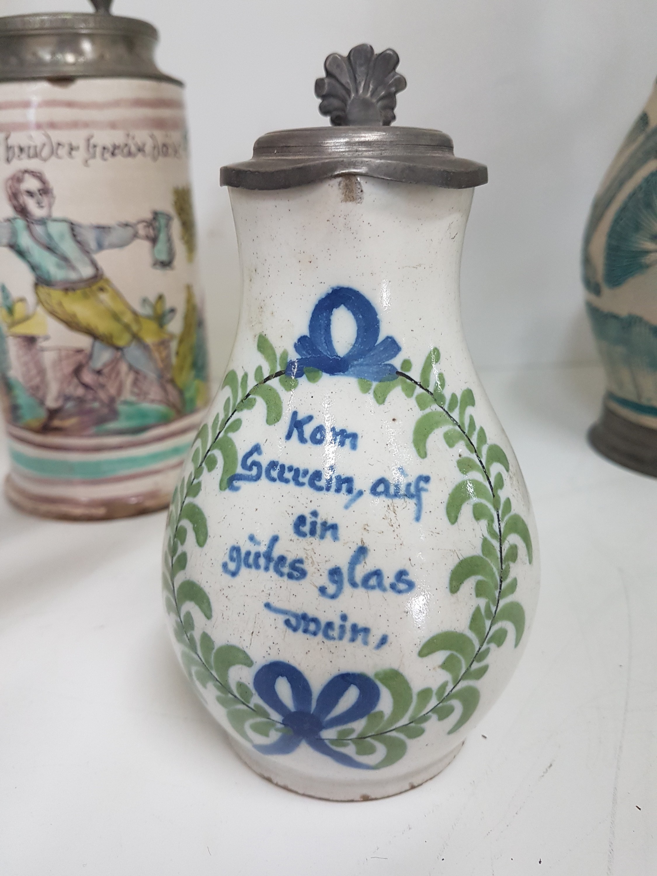 Detail k: Sieben Krüge, deutsch, 18. Jh., meist Fayence, Walzenkrüge mit Zinndeckel, bemalt, ein Krug mit l. Bestoßungen, ein Krug mit Sprung, zwei ...