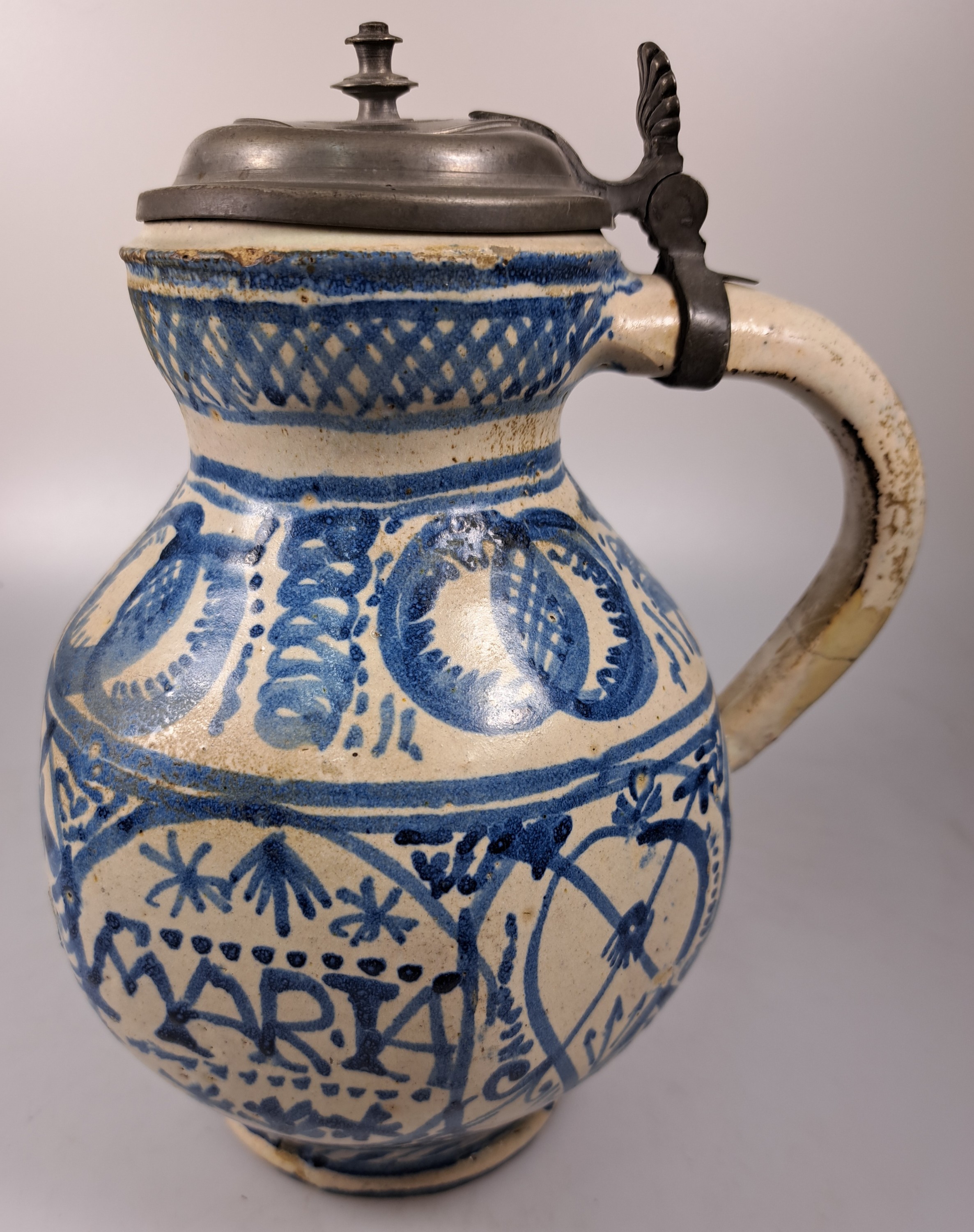 Detail c: Sechskantkrug, Dießen/Ammersee, 17. Jh., Fayence, sechsfach gedrückter Bauch, blaue Scharffeuerfarben, religiöse Motive und Granatäpfel, die ...
