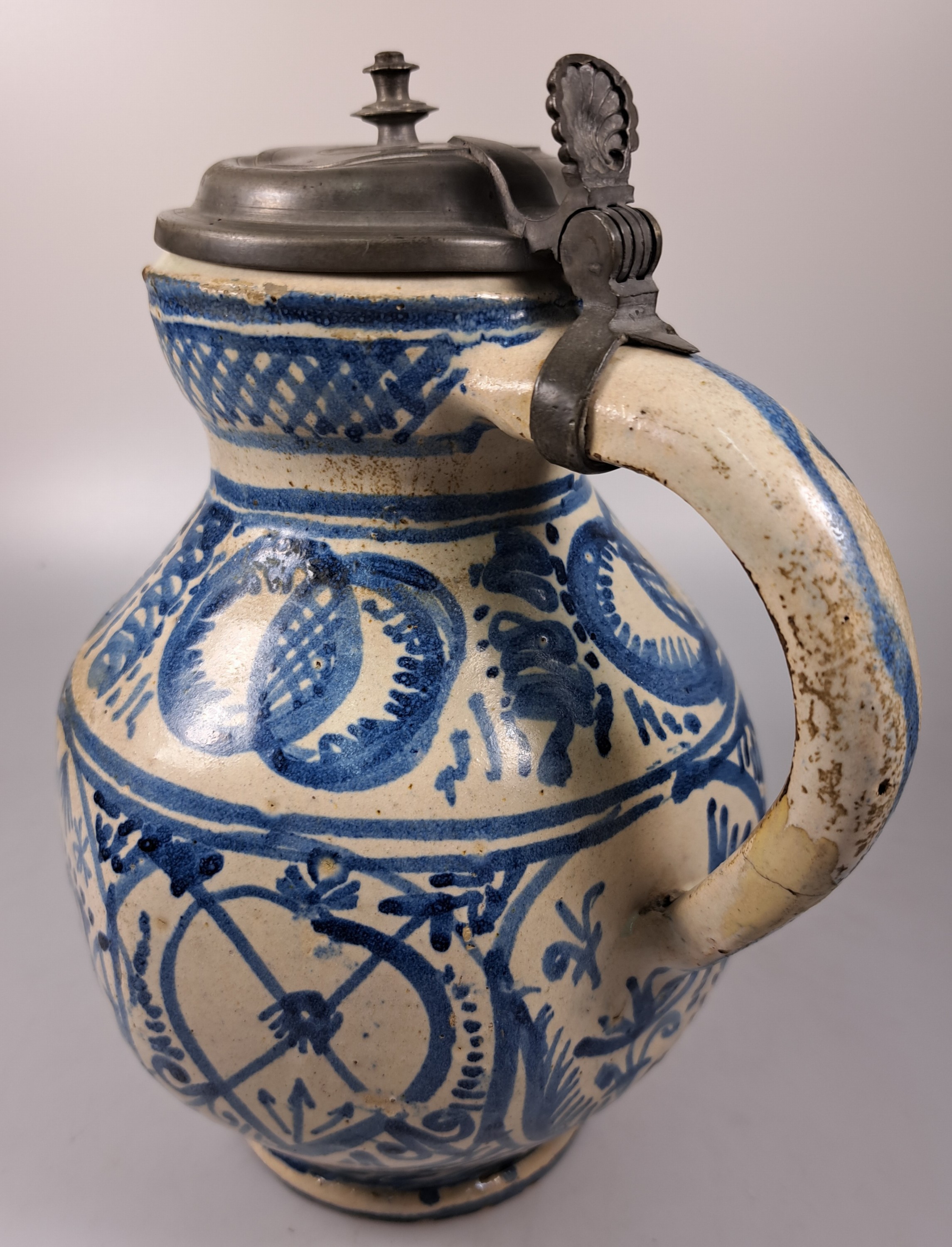 Detail d: Sechskantkrug, Dießen/Ammersee, 17. Jh., Fayence, sechsfach gedrückter Bauch, blaue Scharffeuerfarben, religiöse Motive und Granatäpfel, die ...