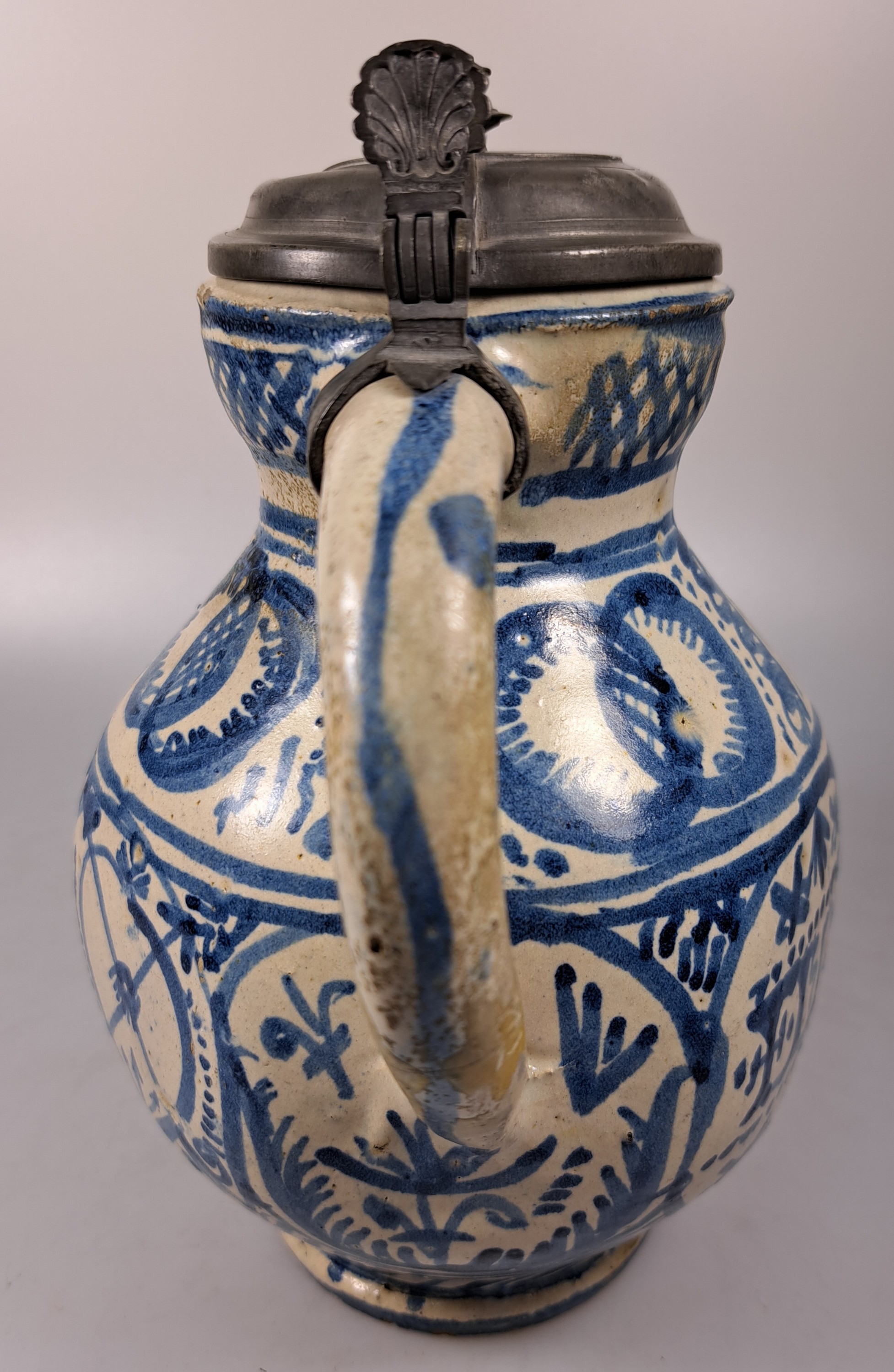 Detail e: Sechskantkrug, Dießen/Ammersee, 17. Jh., Fayence, sechsfach gedrückter Bauch, blaue Scharffeuerfarben, religiöse Motive und Granatäpfel, die ...