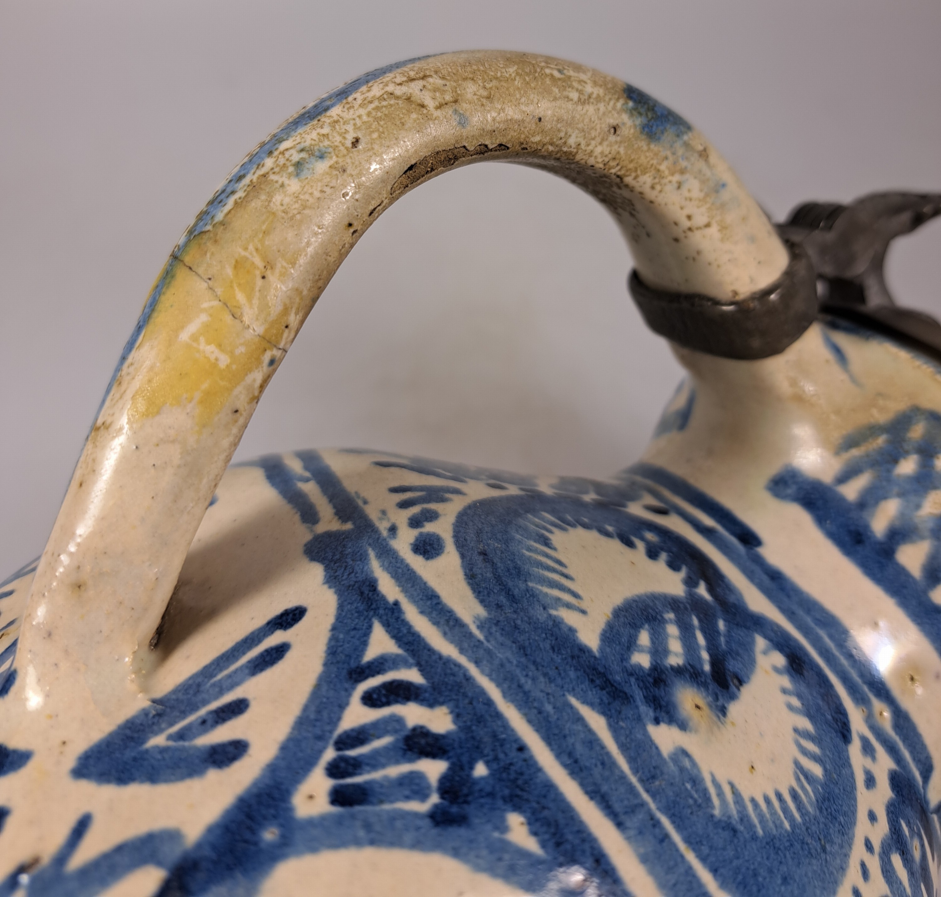 Detail h: Sechskantkrug, Dießen/Ammersee, 17. Jh., Fayence, sechsfach gedrückter Bauch, blaue Scharffeuerfarben, religiöse Motive und Granatäpfel, die ...