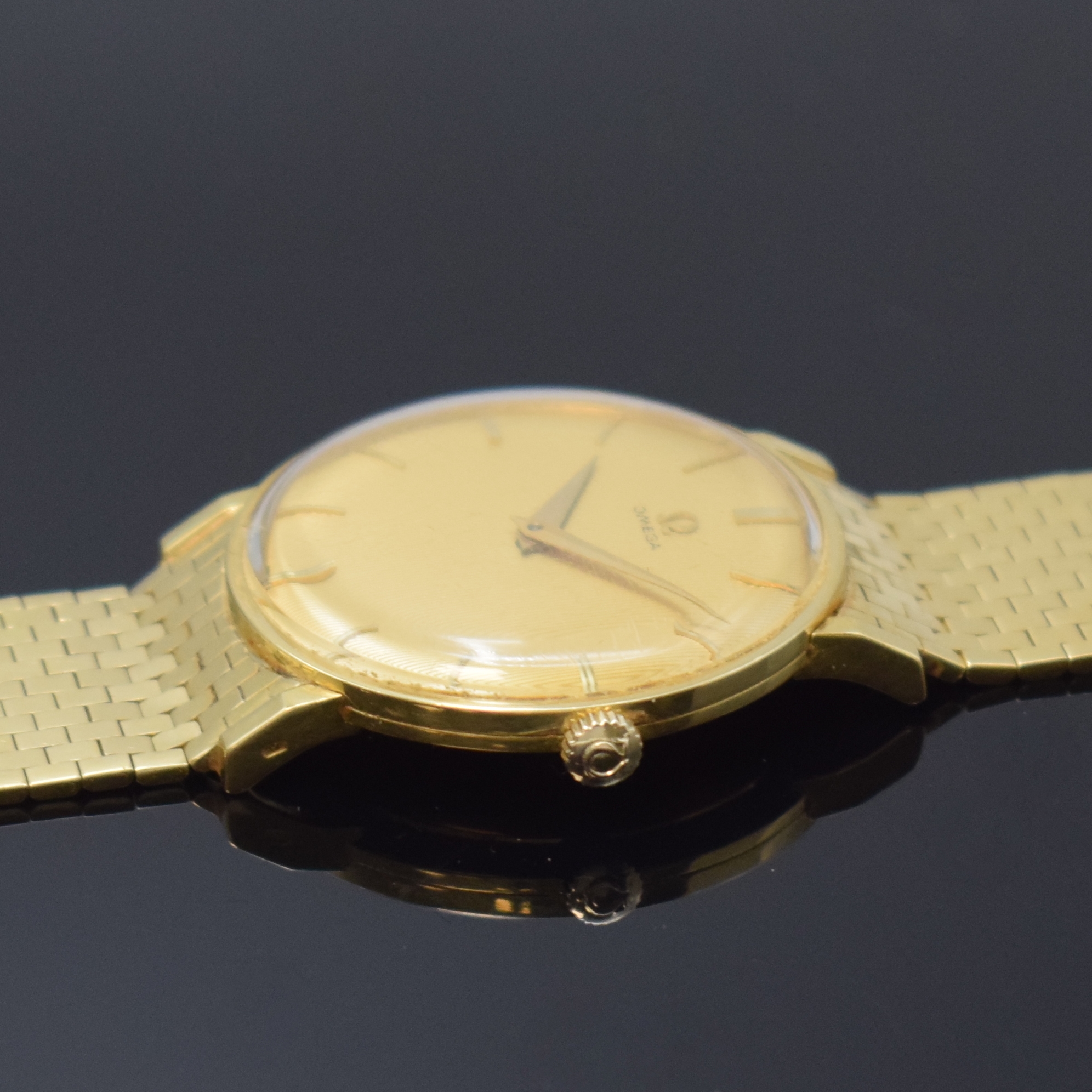 Detail c: OMEGA Herrenarmbanduhr in GG 750/000 Referenz 14372, Schweiz um 1958, Handaufzug, Boden und Glasrand aufgedr., neutr. Backsteinband in GG 750/000 l. ...