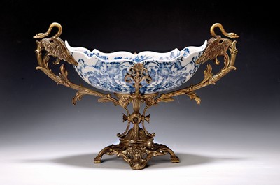 Image 26778700 - Offering bowl, German, end of the 19th century, navette-shaped faience bowl, underglaze blue floral decoration inside and outside, bronze fittings in the Renaissance style, base with masquerades, double handle formed from a pair of swans, 30x44x18 cm, unidentified bottom mark, traces of age
