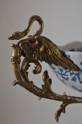 26778700c - Offering bowl, German, end of the 19th century, navette-shaped faience bowl, underglaze blue floral decoration inside and outside, bronze fittings in the Renaissance style, base with masquerades, double handle formed from a pair of swans, 30x44x18 cm, unidentified bottom mark, traces of age