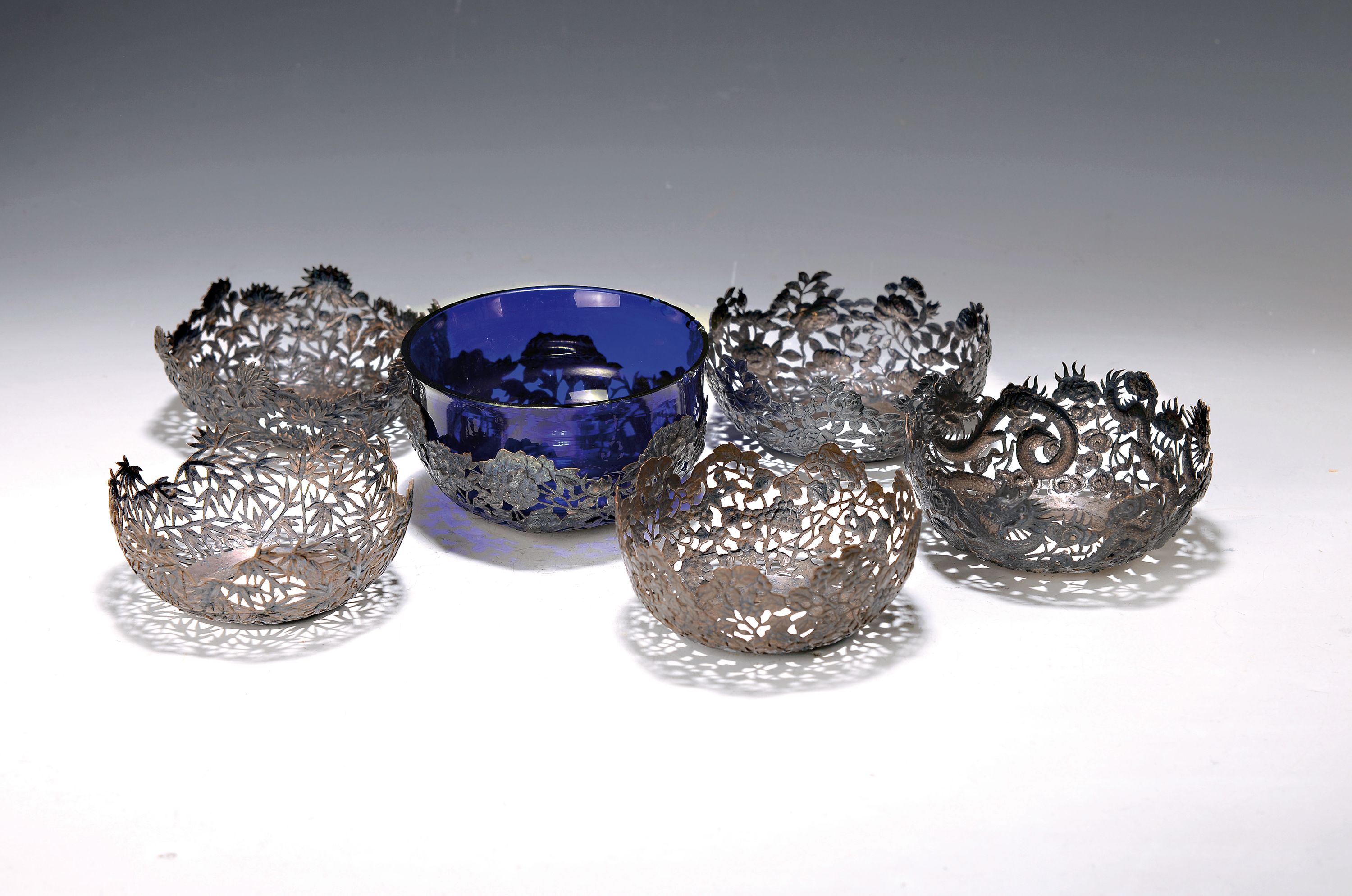 6 Silbermonturen aus China, Anfang, bis Mitte 20. Jh., Glaseinsätze fehlen, versch. Dekore: Blumen, Bambus, Drache, Weintrauben, D. ca. 11.5 cm, ca. ...