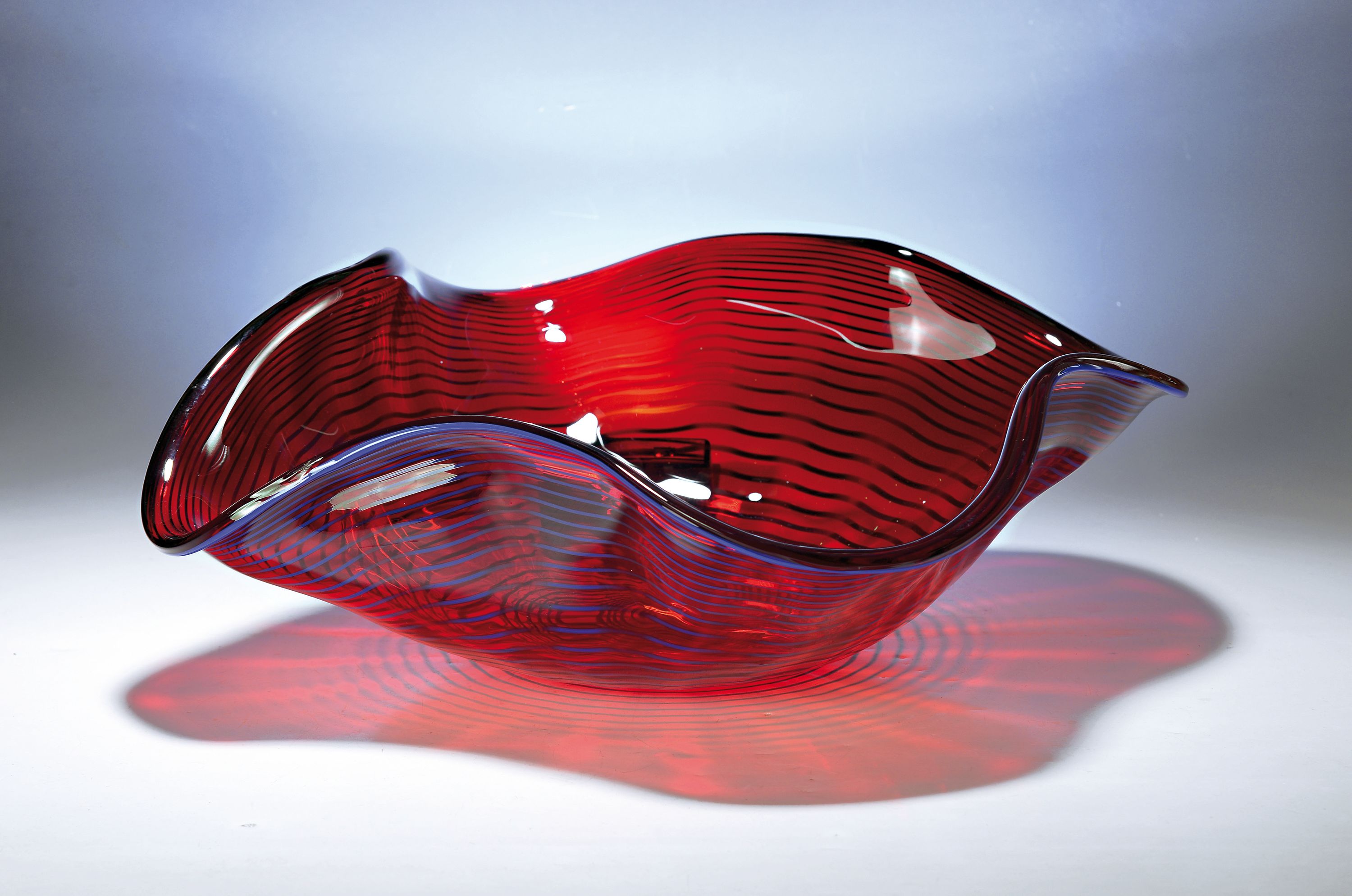 Große Schale, Alberto Dona Murano, weinrotes Glas mit blauer eingekämmter Spirale, mehrfach gebogt, am Boden sign., H. ca. 17cm, D. ca. 50cm