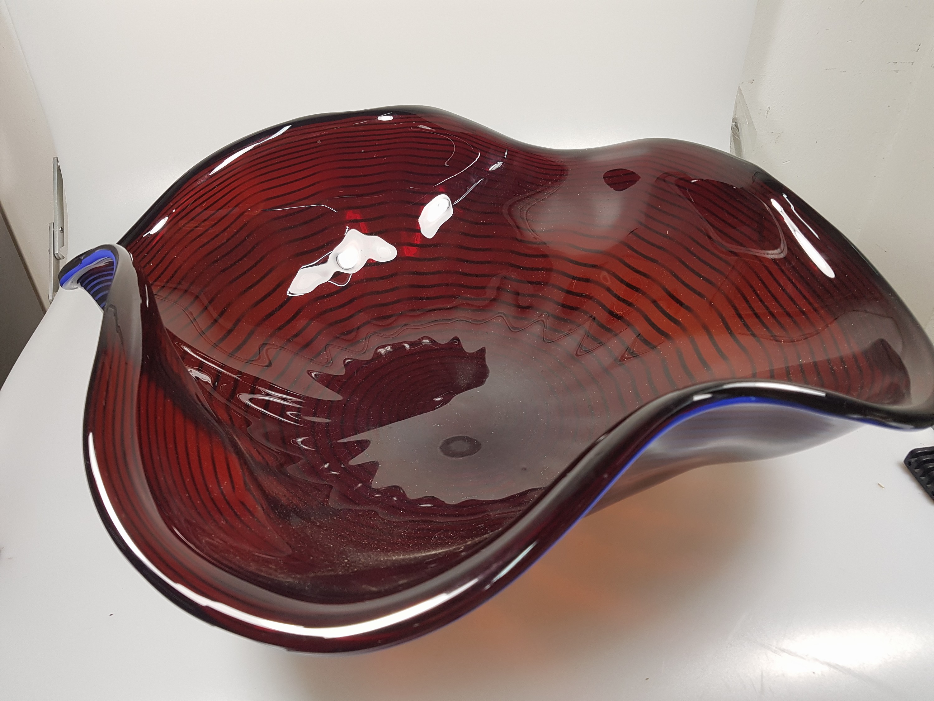 Detail b: Große Schale, Alberto Dona Murano, weinrotes Glas mit blauer eingekämmter Spirale, mehrfach gebogt, am Boden sign., H. ca. 17cm, D. ca. 50cm