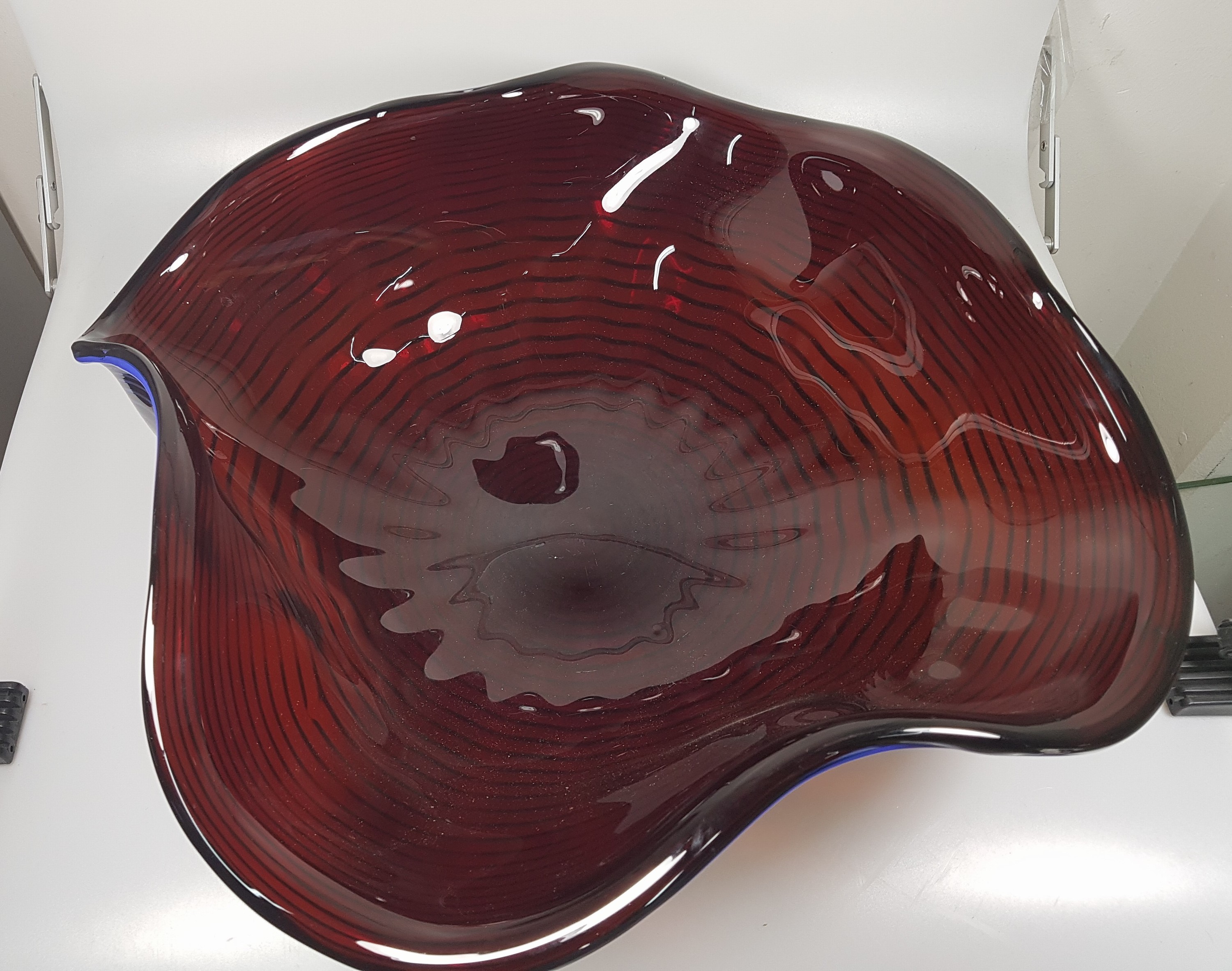 Detail c: Große Schale, Alberto Dona Murano, weinrotes Glas mit blauer eingekämmter Spirale, mehrfach gebogt, am Boden sign., H. ca. 17cm, D. ca. 50cm