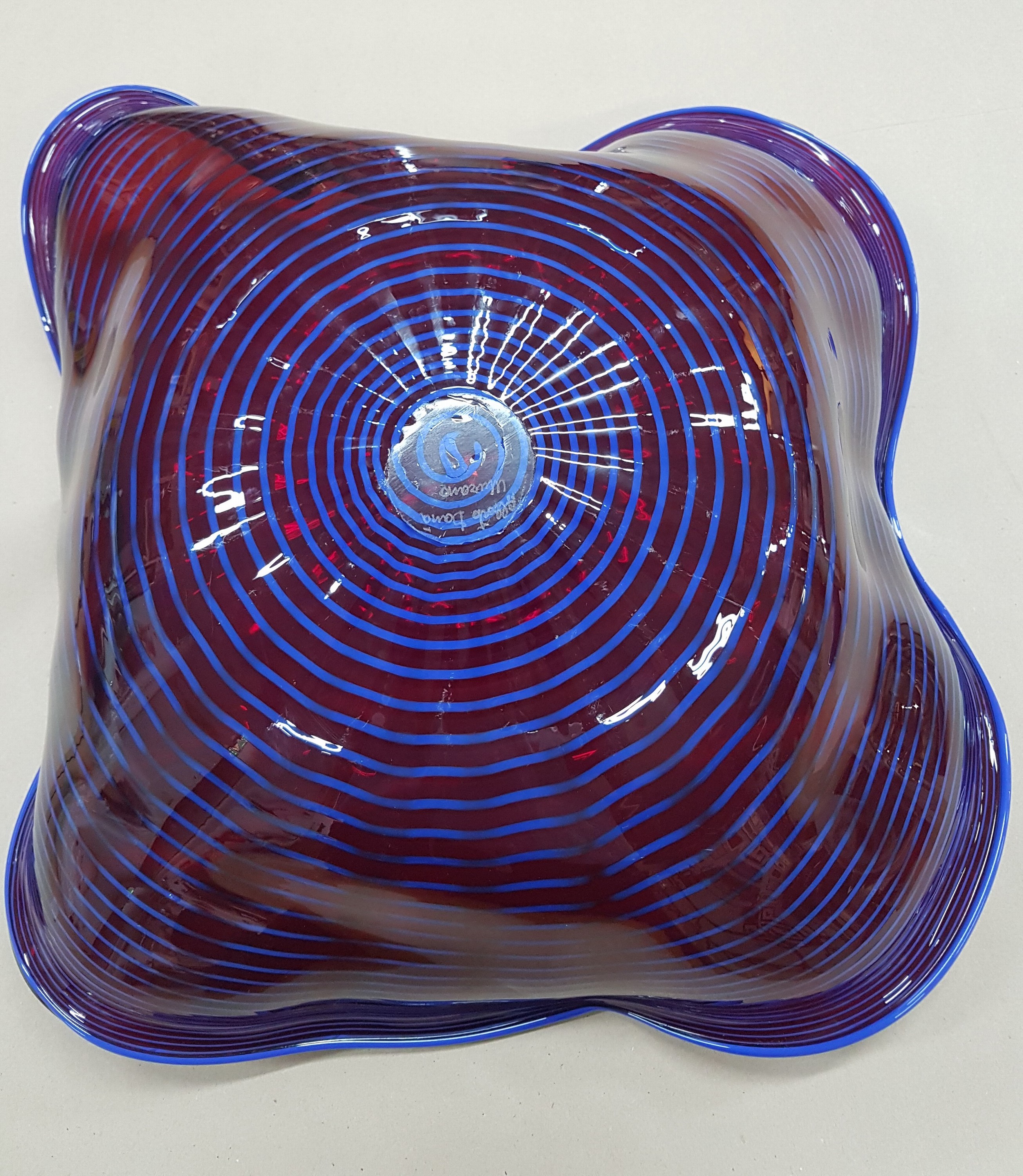 Detail e: Große Schale, Alberto Dona Murano, weinrotes Glas mit blauer eingekämmter Spirale, mehrfach gebogt, am Boden sign., H. ca. 17cm, D. ca. 50cm