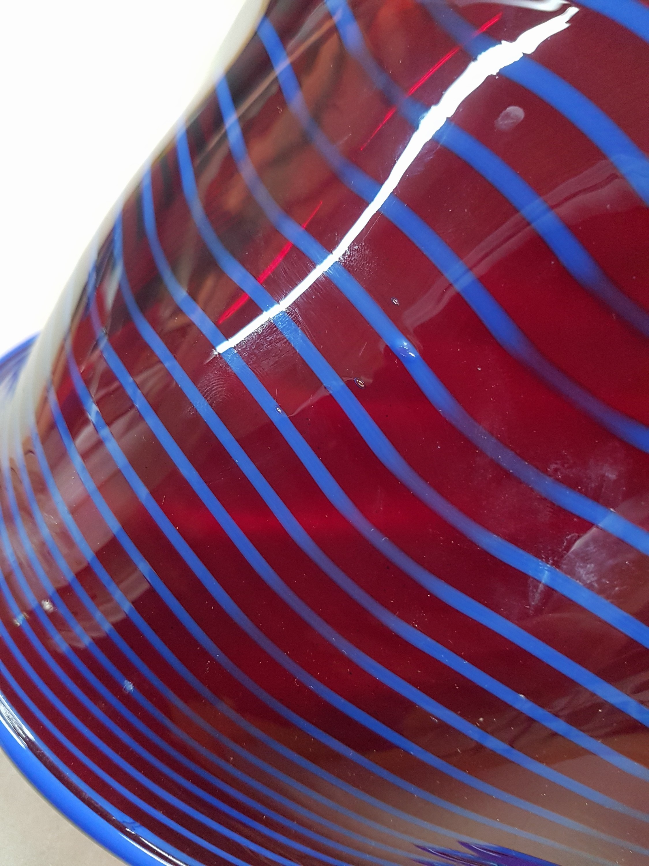 Detail g: Große Schale, Alberto Dona Murano, weinrotes Glas mit blauer eingekämmter Spirale, mehrfach gebogt, am Boden sign., H. ca. 17cm, D. ca. 50cm